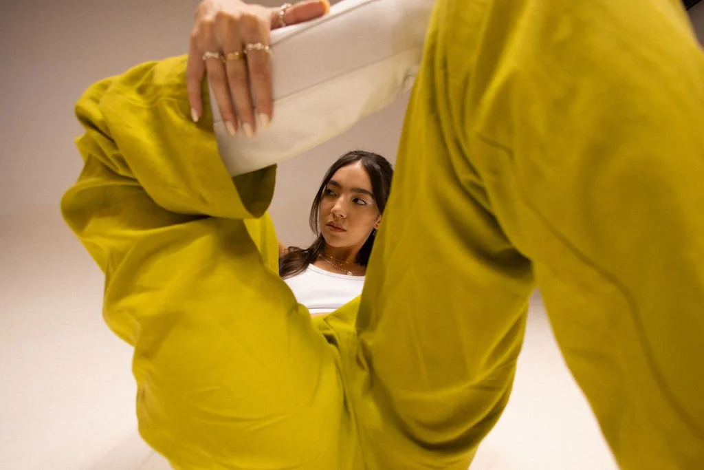 A woman with dark hair looking down at another person in yellow pants holding a white object, taken from below.