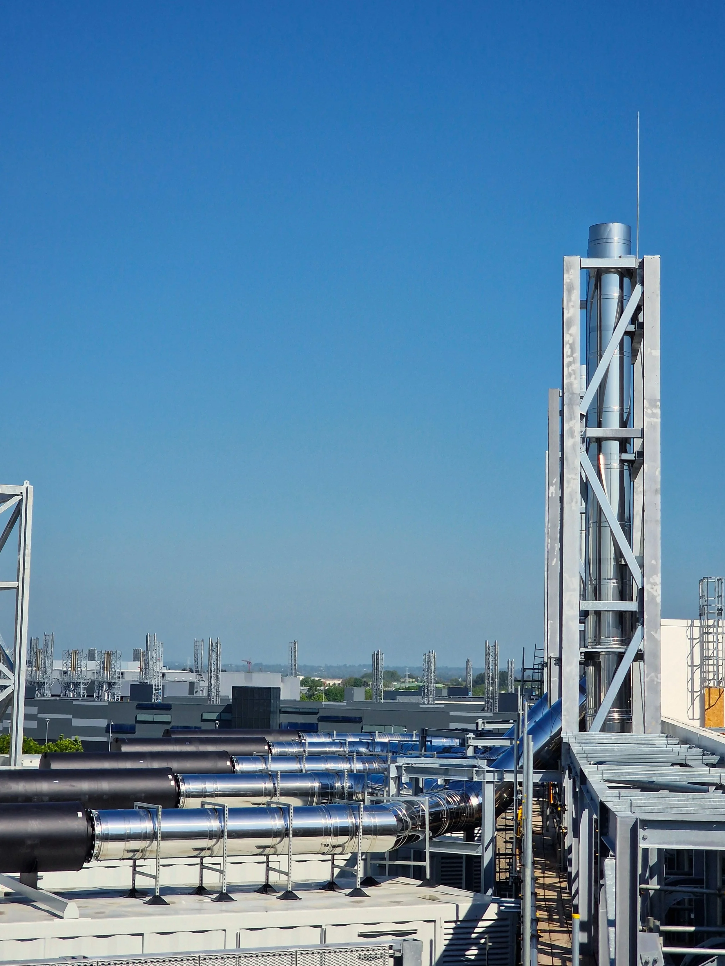 Rooftop view of a data centre with multiple twin‑wall stainless steel flue systems.