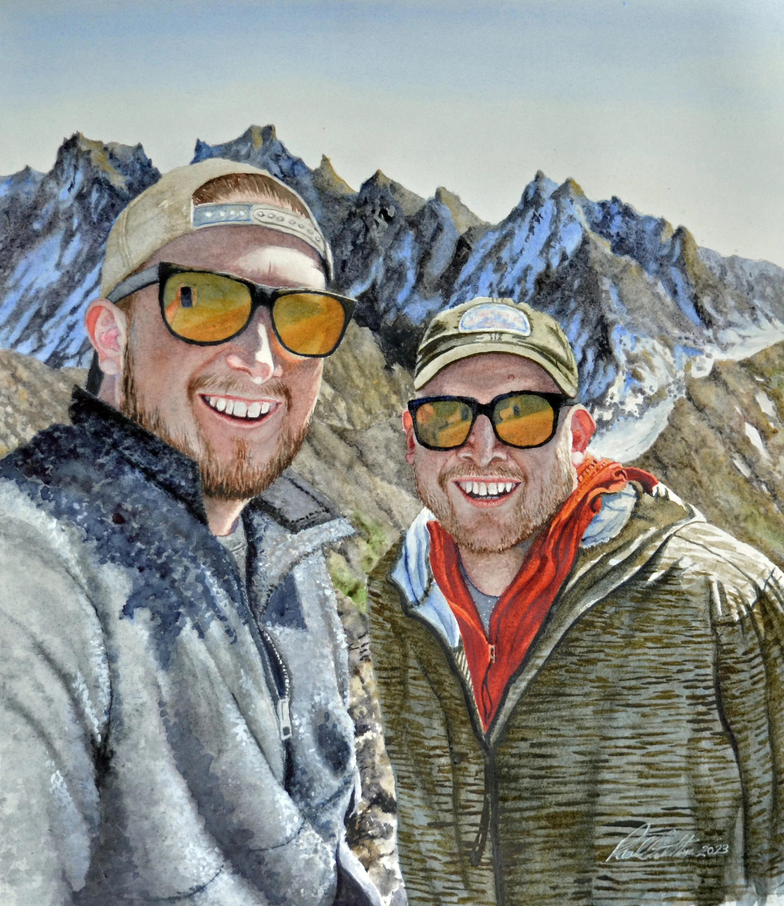 A watercolor painting of two men wearing sunglasses, hiking in a mountainous area with rugged peaks in the background. One man is smiling and wearing a beige cap, while the other has a neutral expression, wearing a similar cap. There are leafless trees and a body of water in the distance. The artist's signature and the year 2023 are visible at the bottom right of the painting.