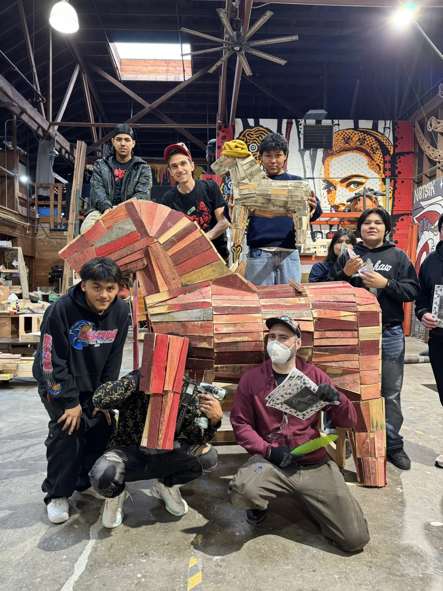 teenagers in an art studio with a giant wooden horse sculpture