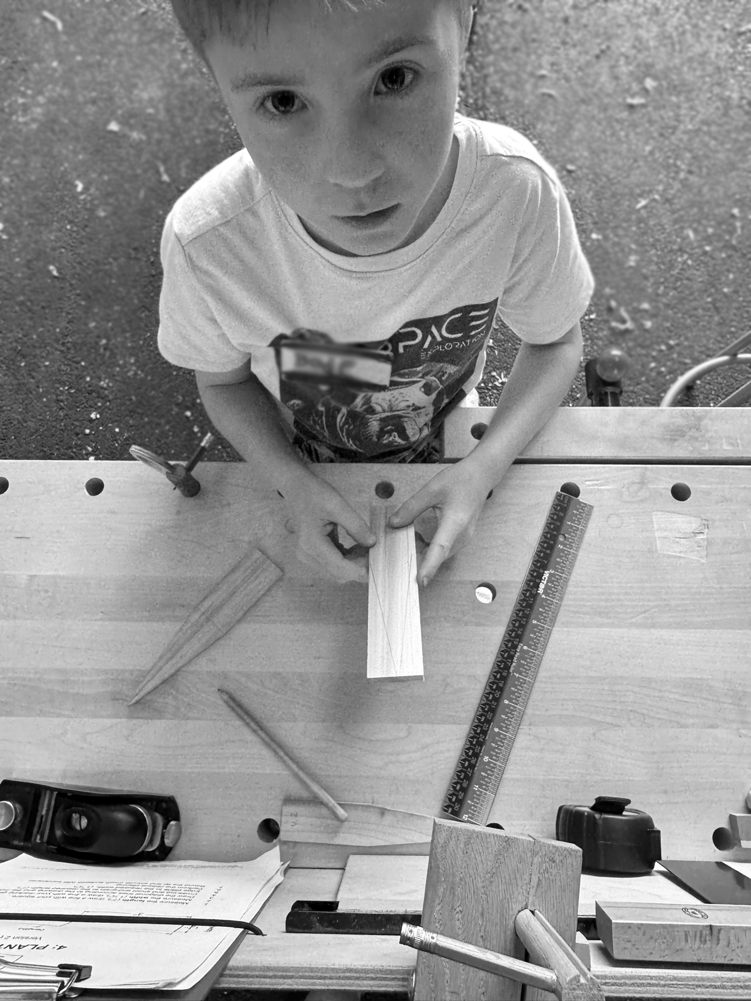 boy looking up woodworking bench