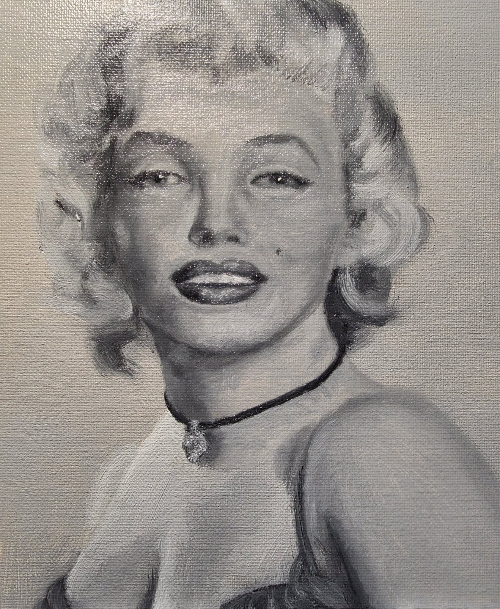 A black and white portrait of a woman with styled hair, wearing a necklace, with makeup.