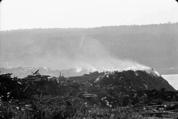 Black and white image of a smoking dump site.