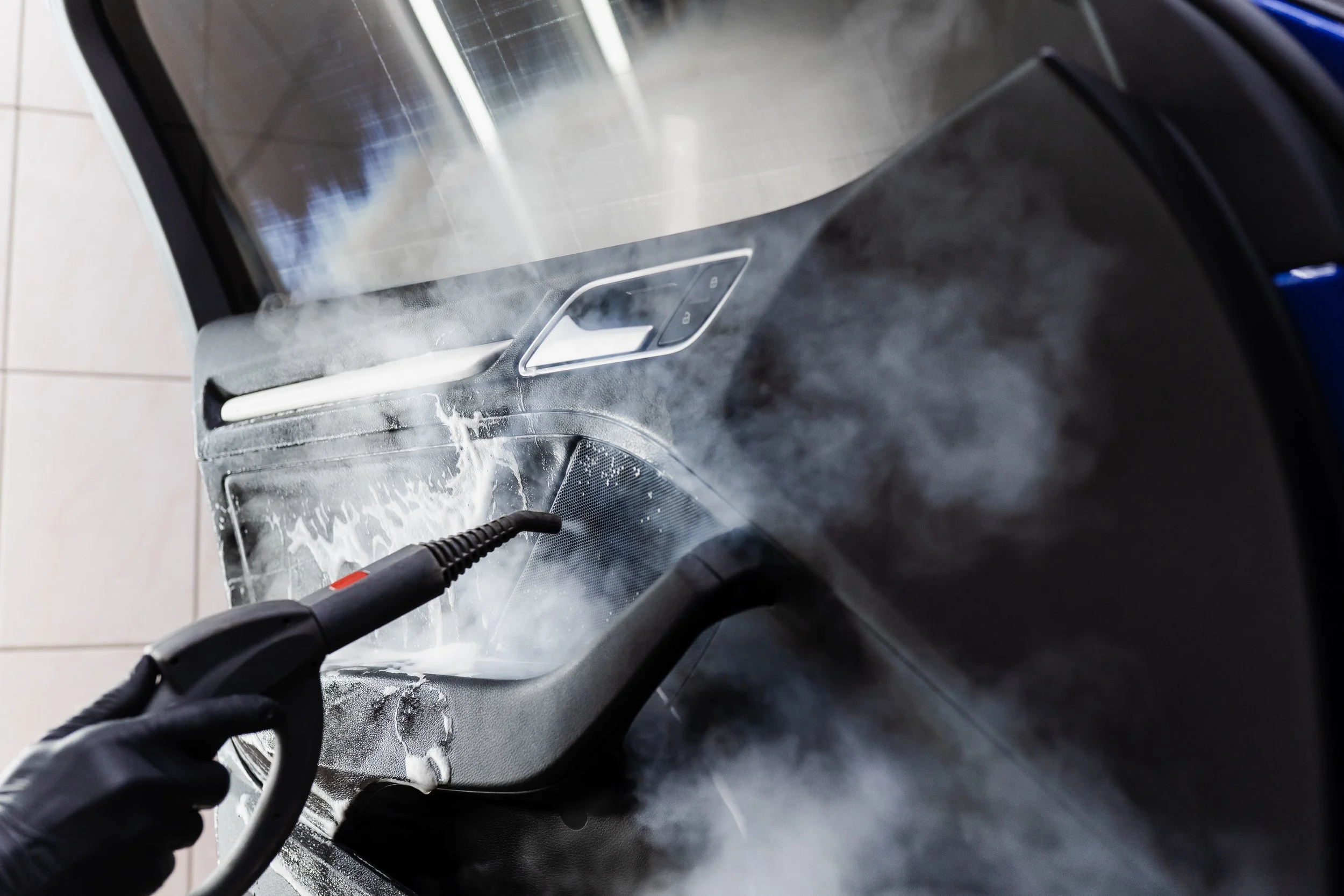 Mobile detailer steam cleaning a car door jamb during an interior detail in Elk Grove, CA