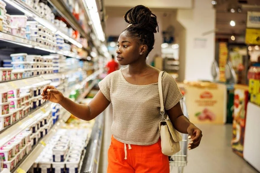 Customer choosing between products in a supermarket while making a brand purchasing decision