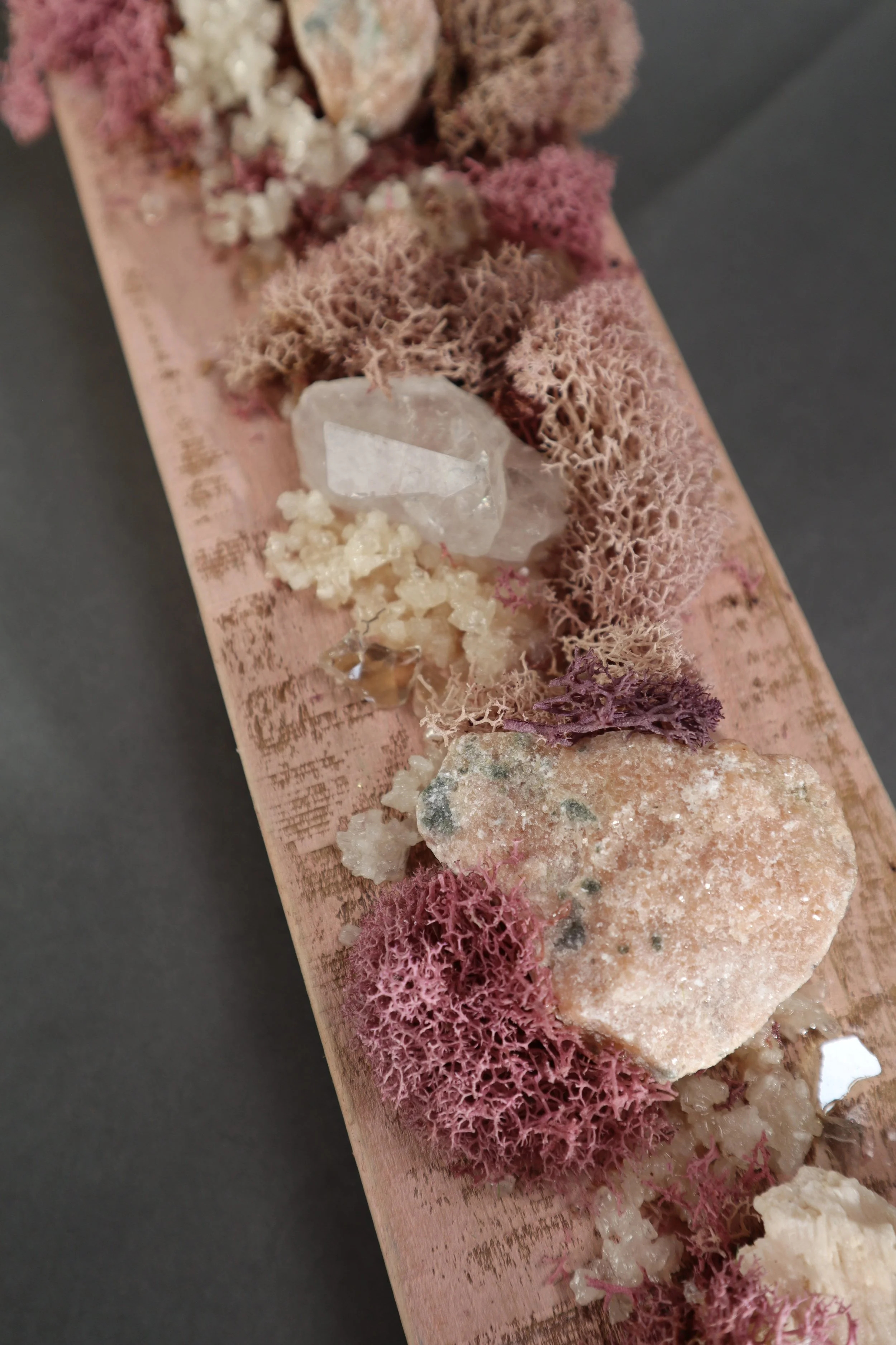 Pink mineral wall decor with clear quartz, dolomite, sunstone and natural stone textures on wood