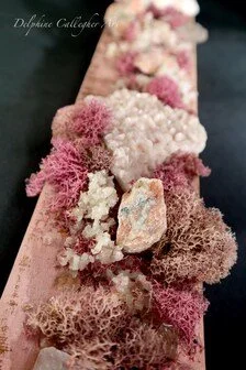 Vertical pink mineral wall sculpture with clear quartz, sunstone and seashell details on natural wood