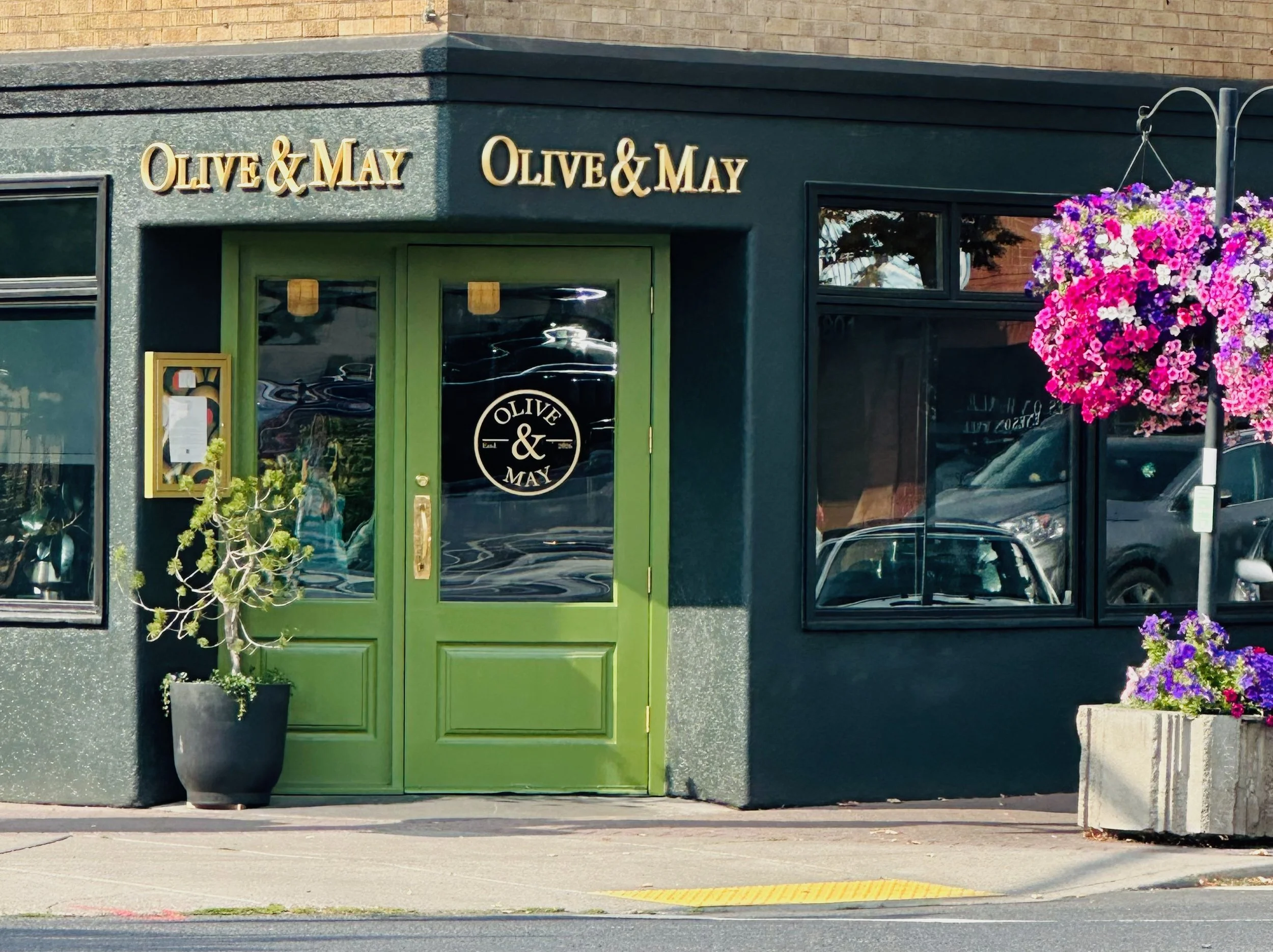 Olive & May Restaurant, Northern Mediterranean food, green doors, and hanging flower baskets.