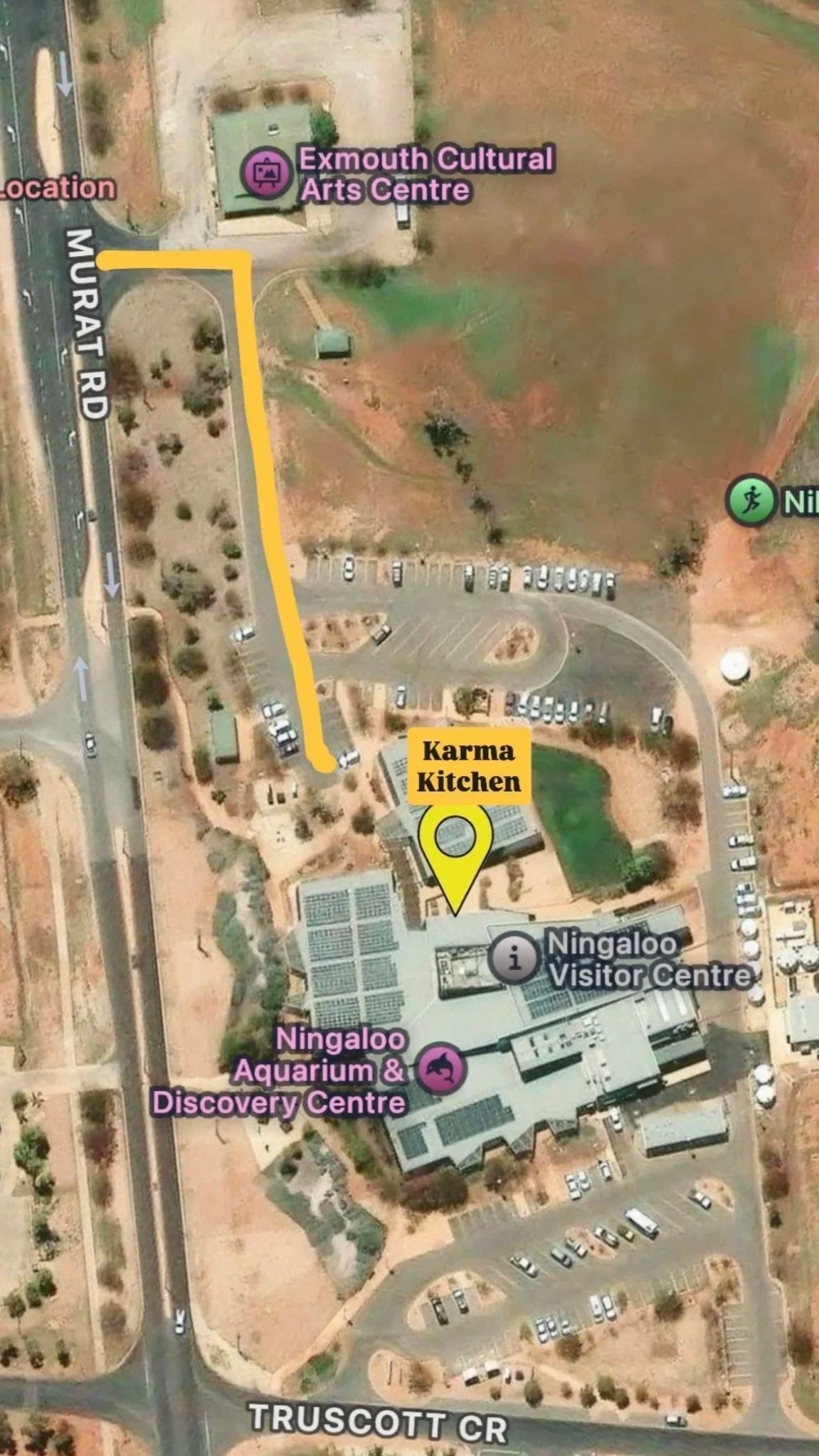 Map showing the route from Ningaloo Aquarium & Discovery Centre to Karma Kitchen at Exmouth Cultural Arts Centre, with a yellow line marking the path, surrounding parking lots, and labels for the locations.