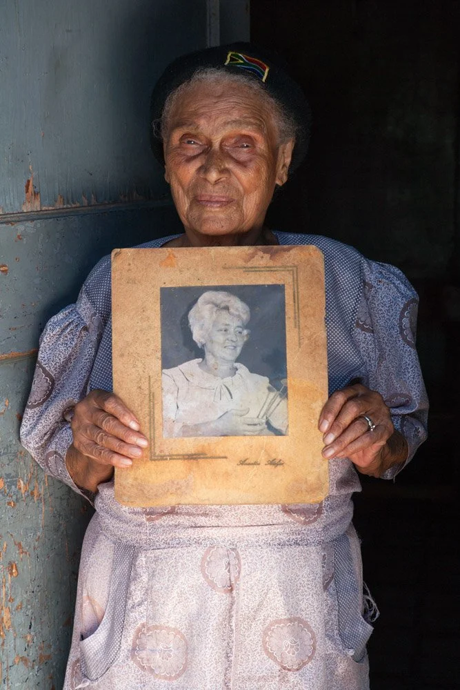 Mrs Lefosa, posing with a portrait of her former employer. 
(Batho Location, Mangaung, Free State).