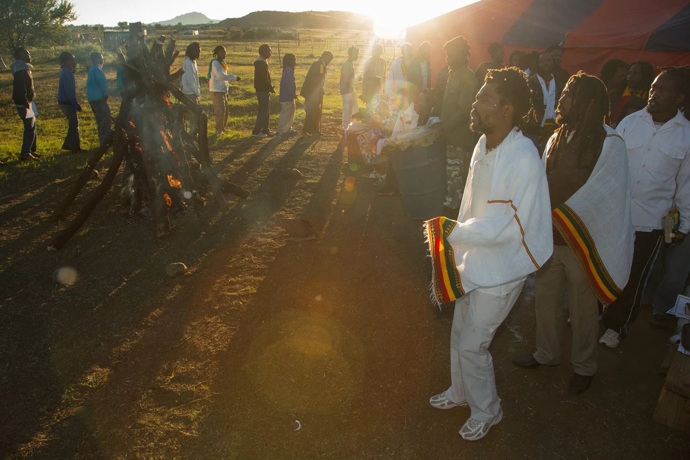 Brethren and sistren touring the Fire Key at sunrise. The community circles the fire in a continuous, chanting procession to purify and seal the sacred ground.