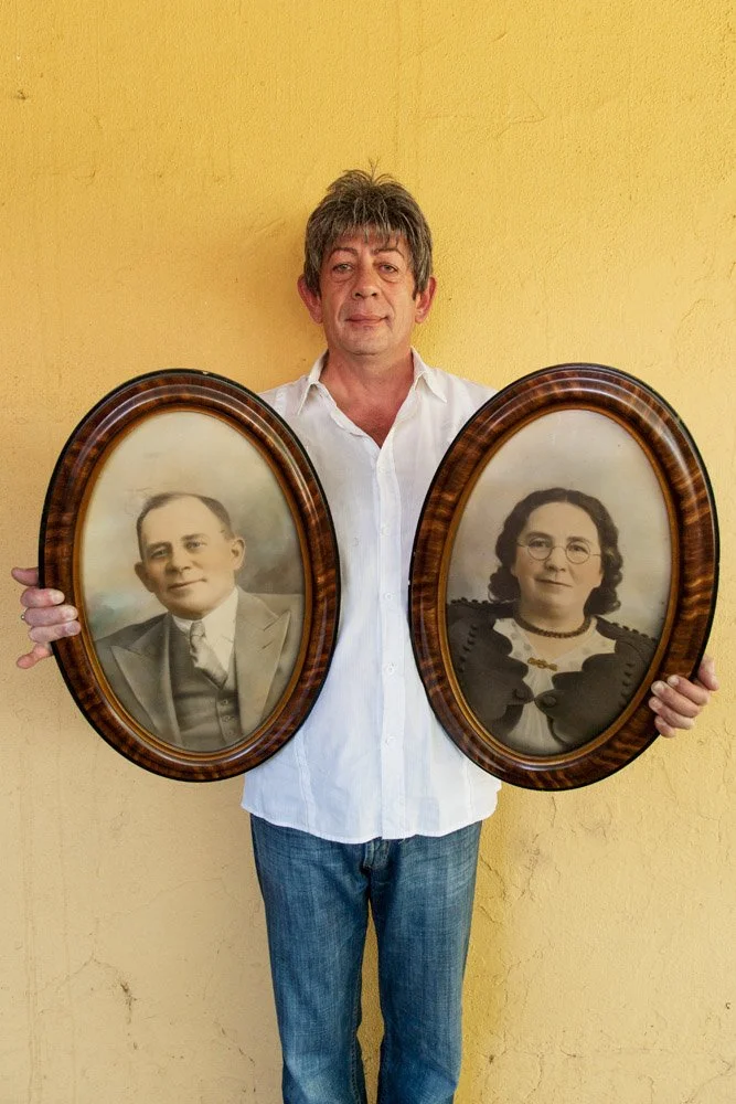 Ernst Jordaan holds the framed, hand-coloured portraits of his grandparents. Mr. Jordaan is a psychic medium, author and gay rights activist. 
(Fleurdal, Mangaung, Free State).