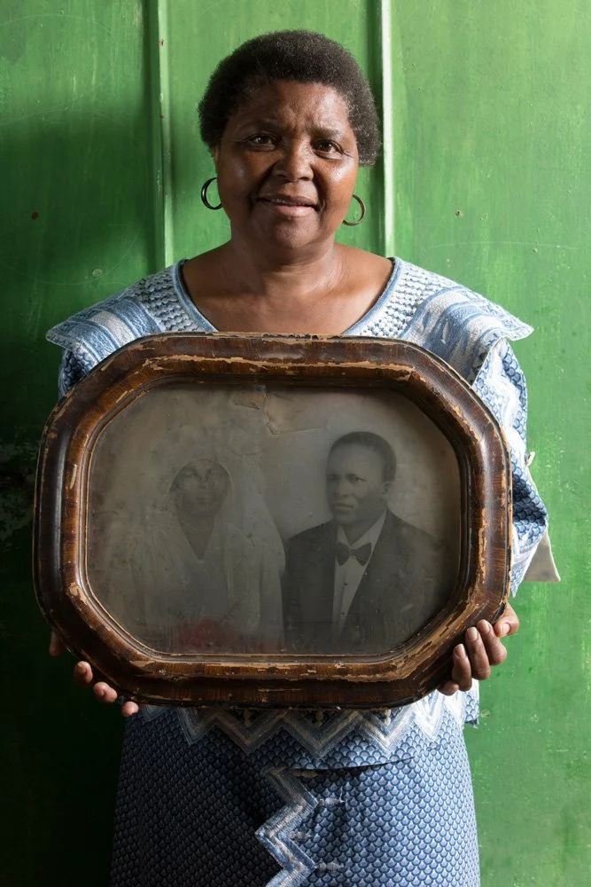 Seipati Manake holds a framed, hand-coloured black-and-white photograph of her grandparents, Elymus Pitso Manake  and Alina Motshidiso Teboho Manake. (Phahameng/Bultfontein, Free State).