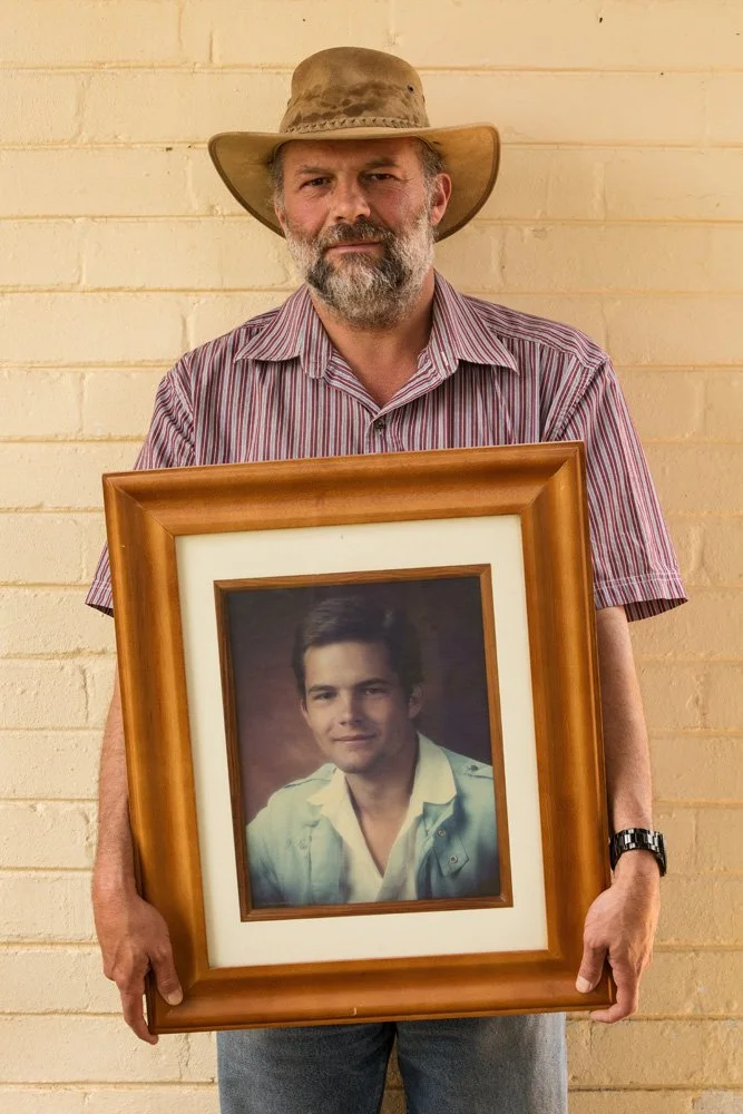 Andre Stephan Karsten holds a framed colour photograph, printed on canvas, of himself as a teenager. Mr. Karsten teaches at the Jimmie Roos Skool, a reform school for boys. (Dewetsdorp, Free State).