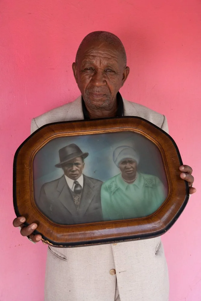The late Reverend Israel G. Swanepoel, posing with a portrait of his parents. (Batho Location/Bloemfontein, Free State).
