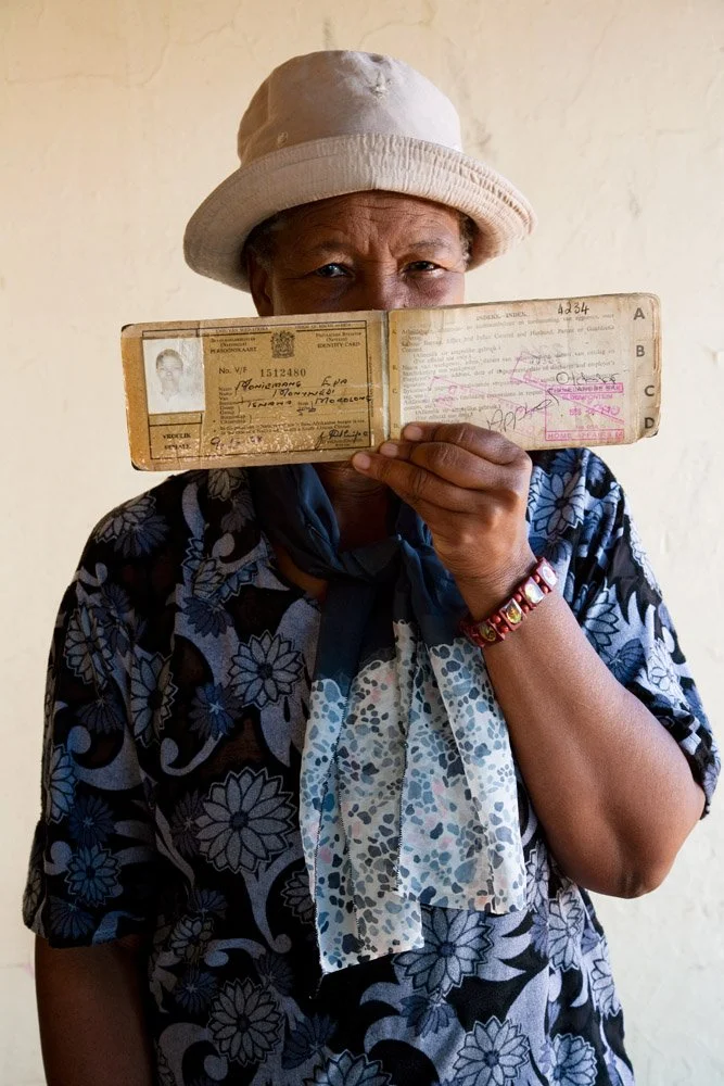Moniemang Eva Montwedi, posing with her dompas. The identity photo depicts her as a young woman. The pass was conceived to restrict black people's freedom of movement in the segregated South Africa. Black citizens found outside their designated 'loca