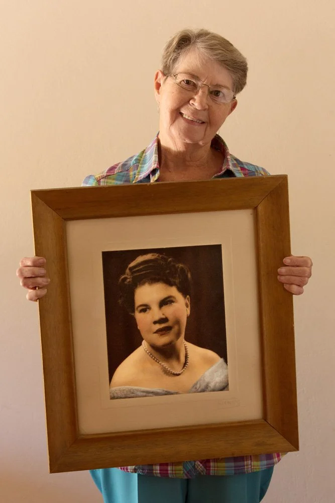 Estelle Van Vuuren is a retired nurse. She holds a framed, analog colour portrait of her mother, Aletta Susanna Ballot. The portrait was made in the 1950s by Werners Studio in Bloemfontein. In 1969, Alette married Jurie Hermanus Van Vuuren Jr, who wa