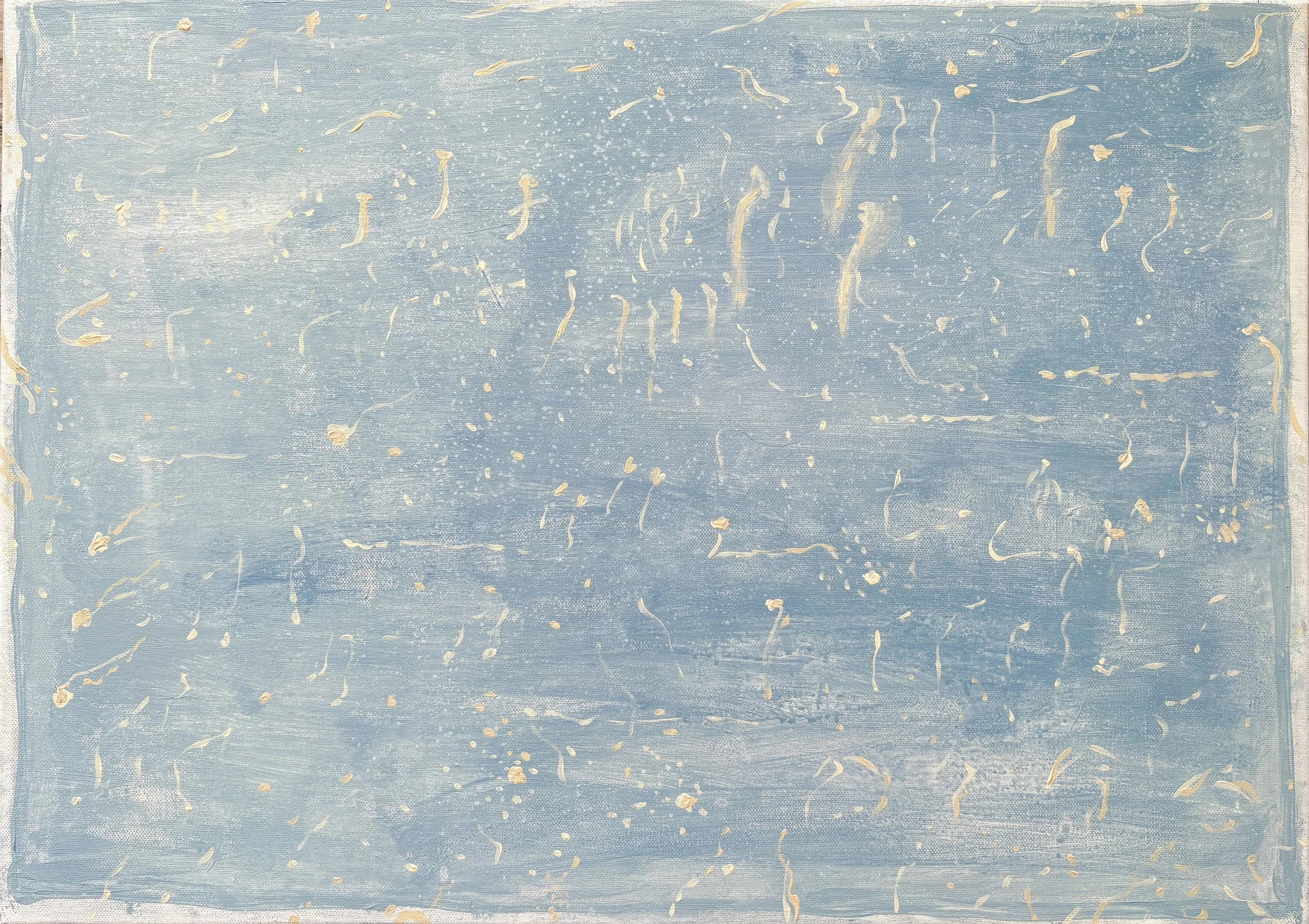 Close-up photograph of a textured, light blue surface with irregular, gold-colored streaks and splashes.