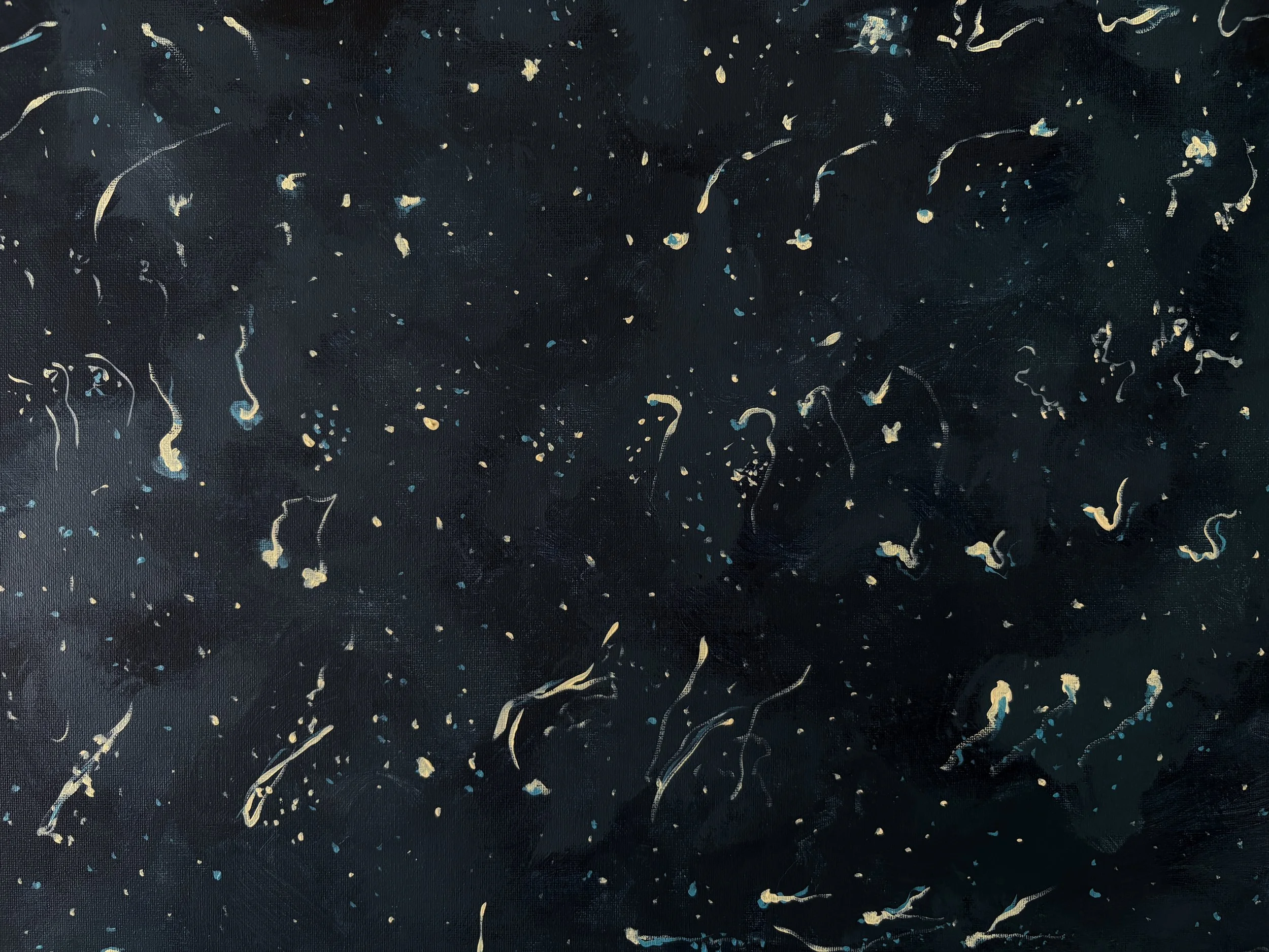 Dark fabric background with scattered gold and light blue threads and small paint splatters.