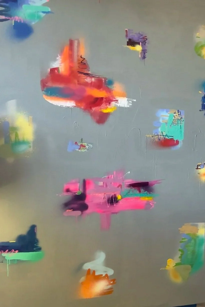 Abstract colorful smudges and streaks on a blurred background with green, orange, pink, yellow, blue, purple, and white colors.