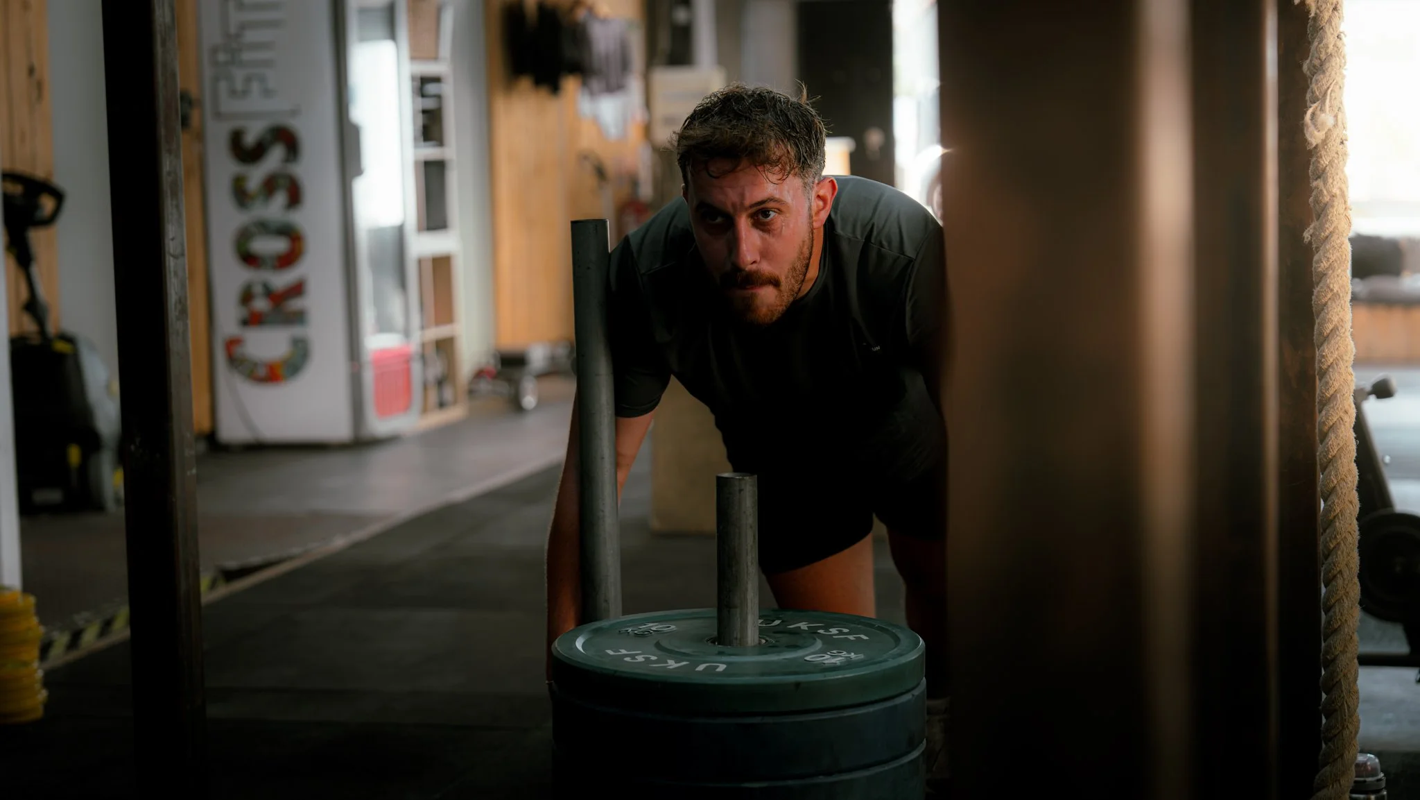 Homme poussant un chariot de poids lors d'une séance d'entraînement dans une salle de sport