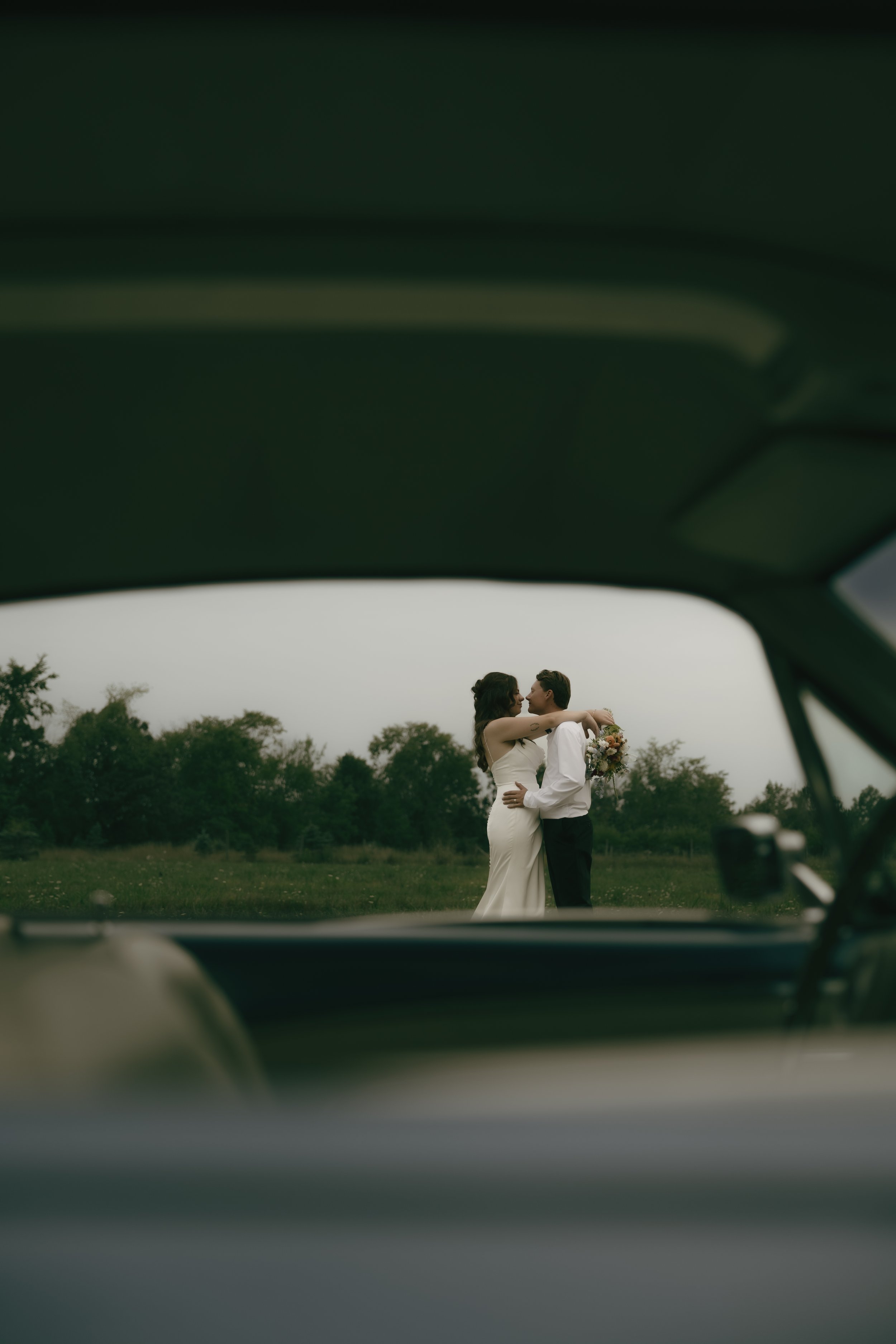 Bride and groom embracing outdoors during candid documentary-style wedding portraits