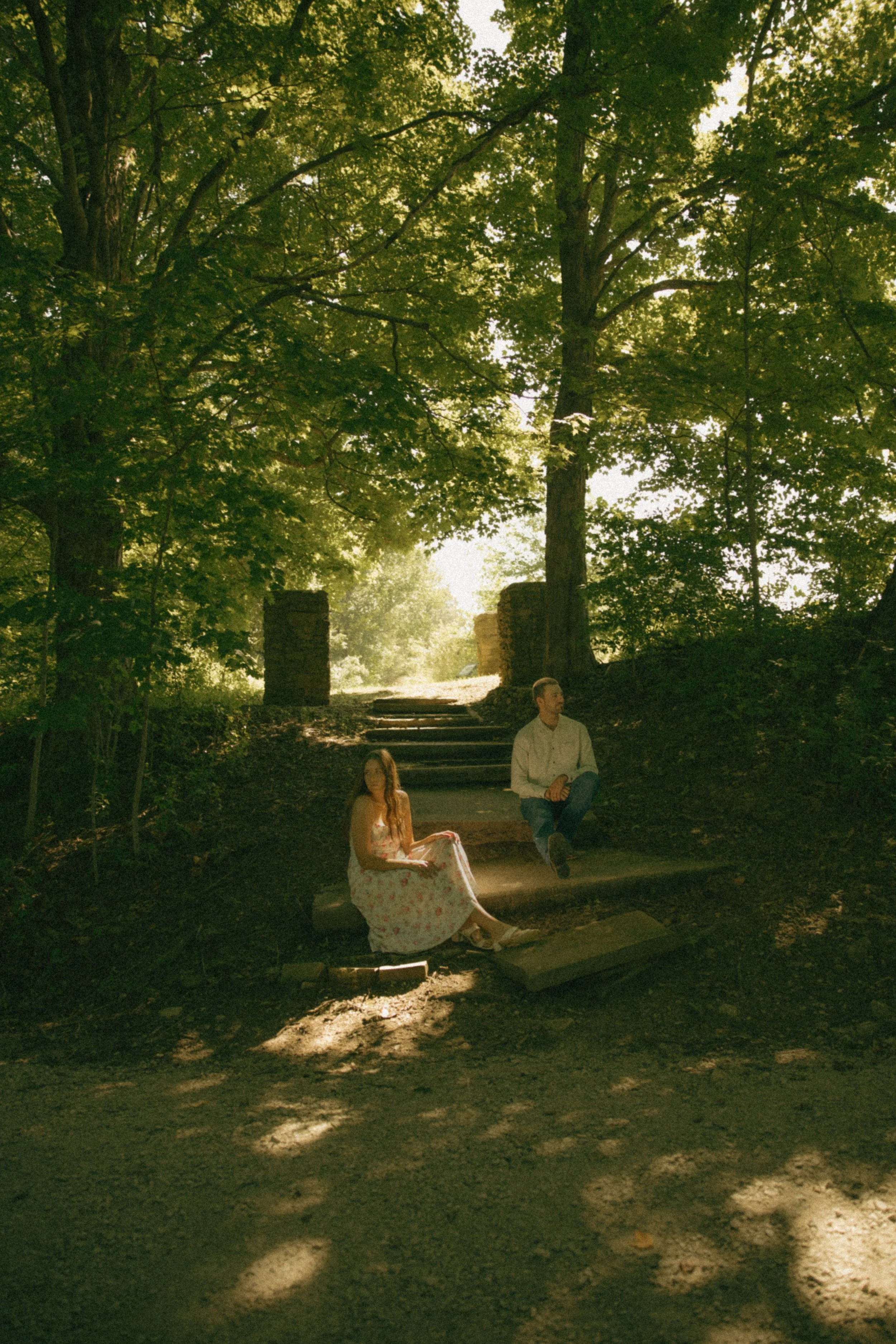 Couple sitting together beneath a large tree during an intimate outdoor couples photography session
