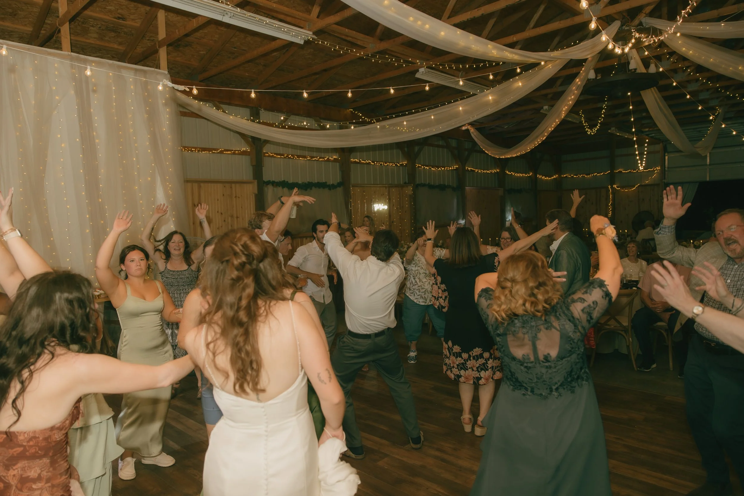 Wedding guests dancing and celebrating during a candid wedding reception