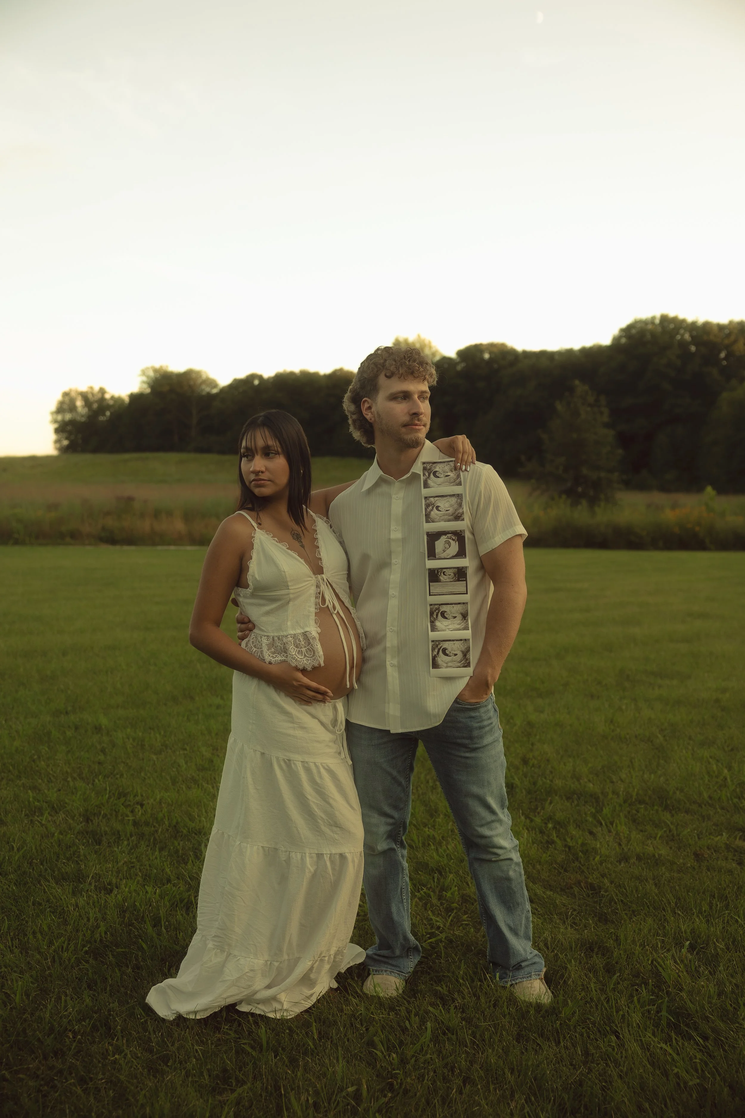 Expecting couple holding ultrasound photos during a sunset maternity photography session
