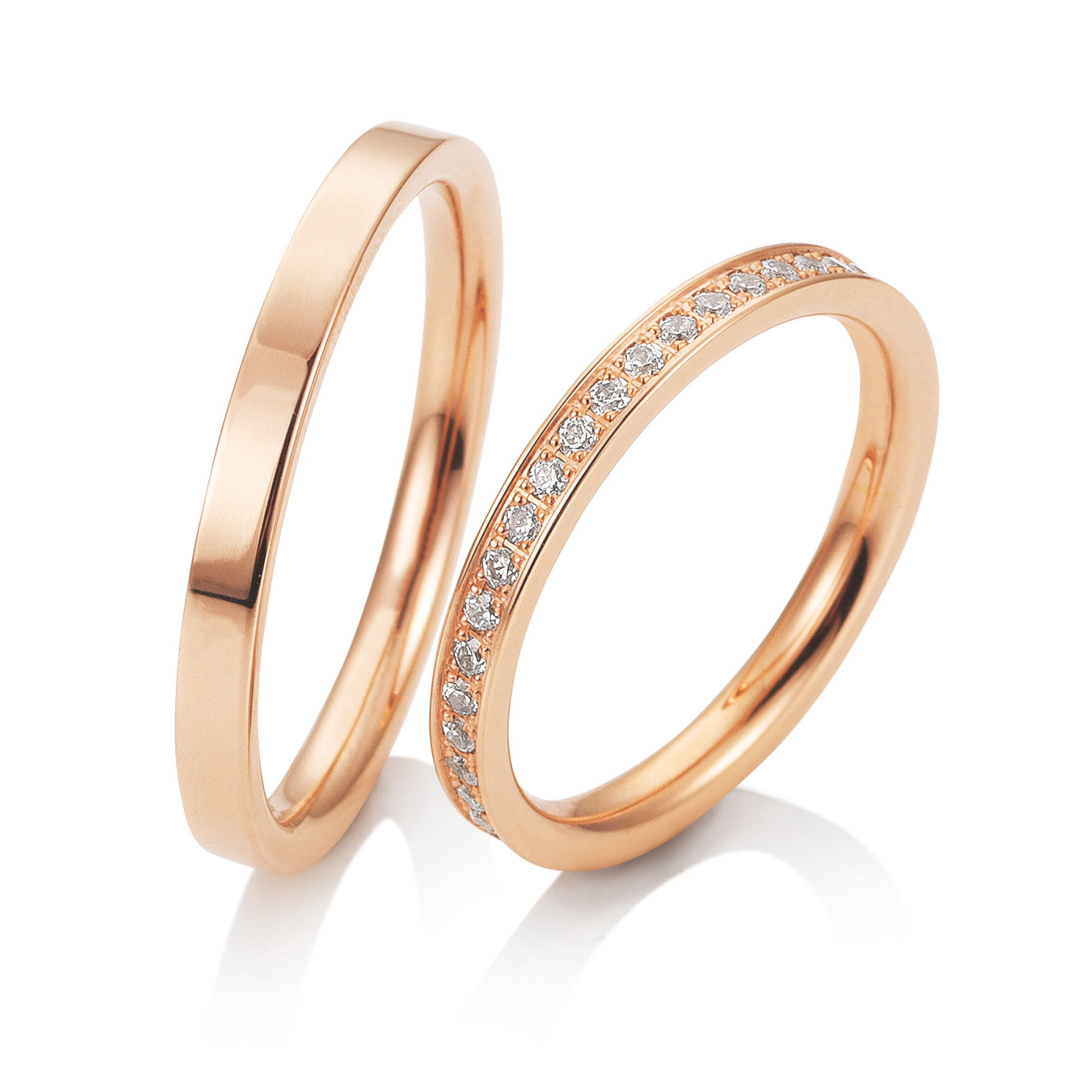 Drei roségoldene Ringe, einer schlicht, einer bearbeitet und einer mit Diamanten besetzt.