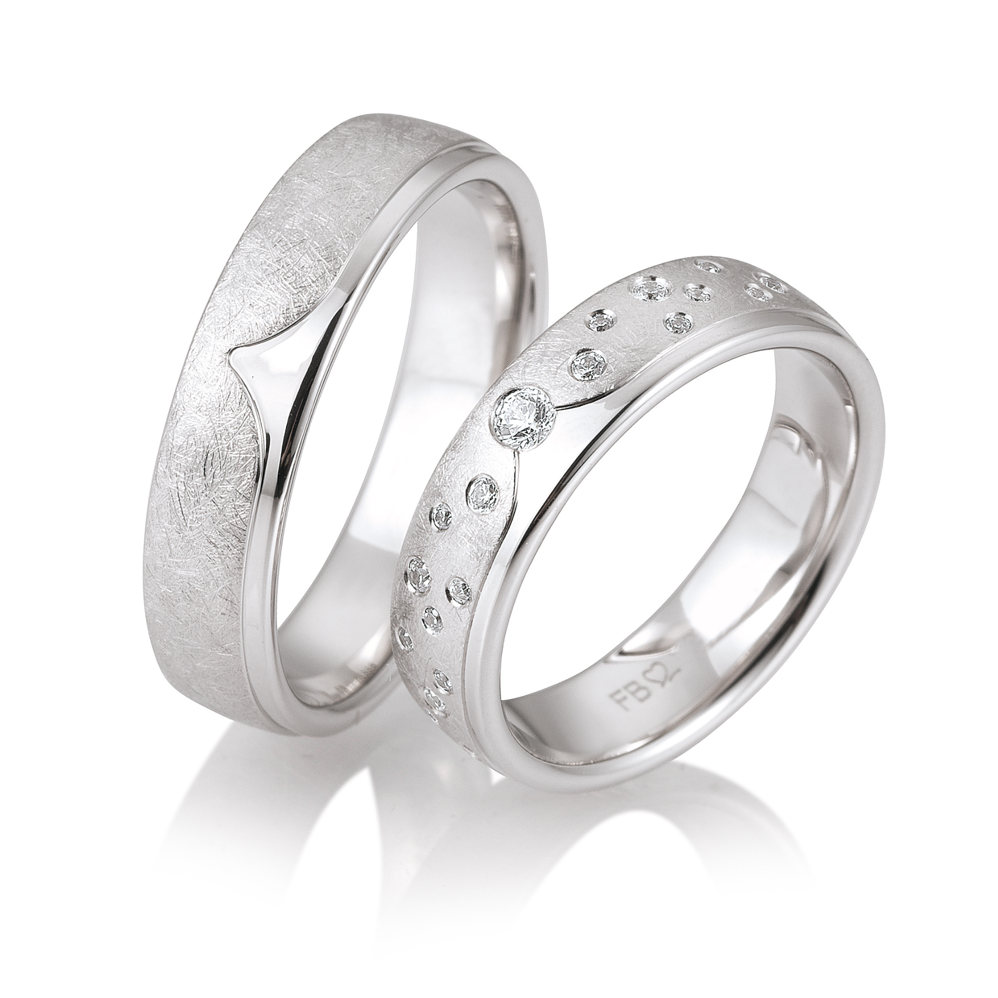 Zwei silberne Ringe, einer mit eingearbeiteten Textur und der andere mit kleinen Diamanten besetzt.