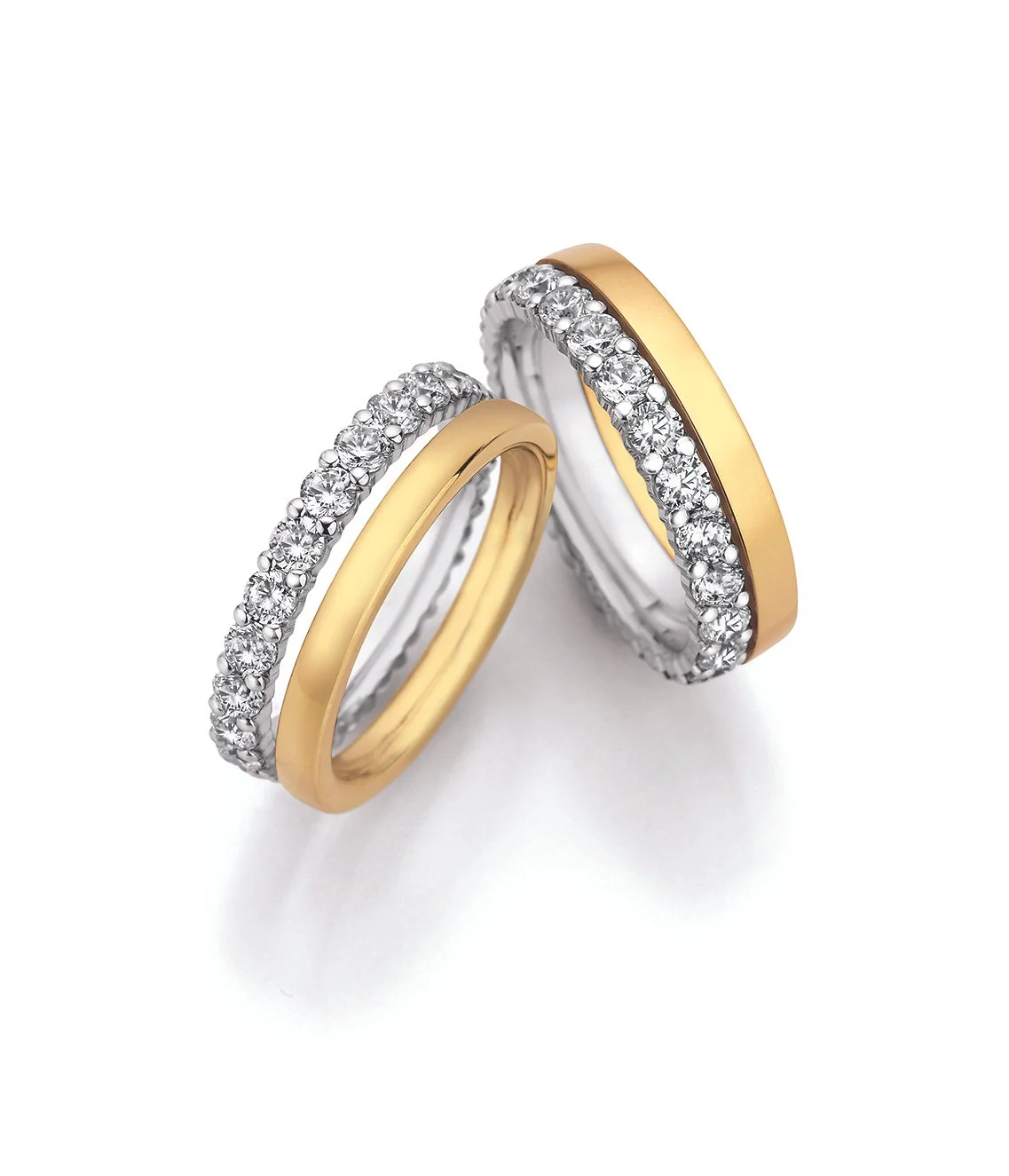 Zwei Trauringe aus Gold und Silber mit Diamanten dessen Steinbesatz individuell angepasst werden kann.