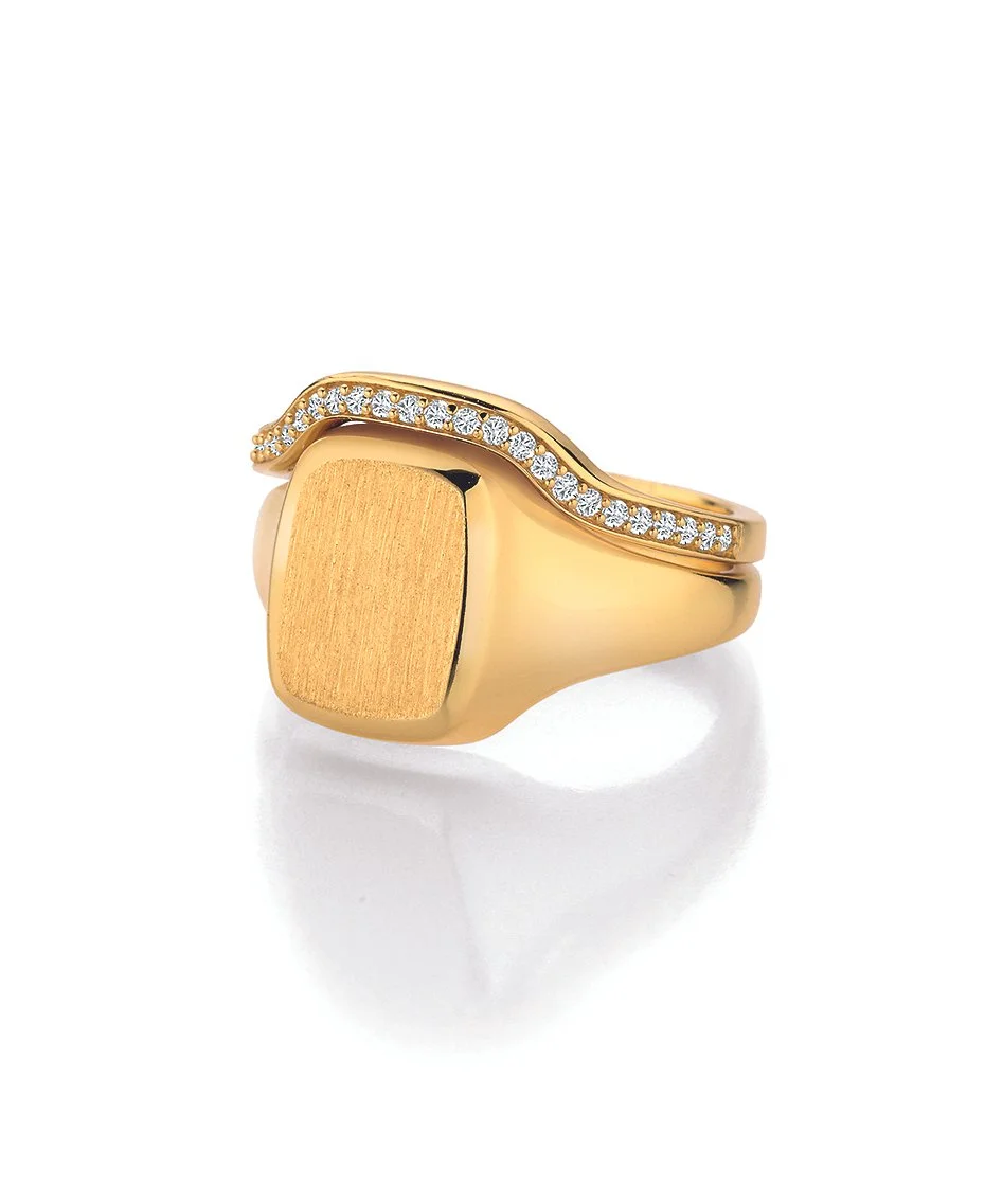 Ein moderner Siegelring mit brillantbesetztem Vorsteckring mit einer quadratischen, mattierten Oberfläche und einer geschwungenen Linie mit kleinen Diamanten auf der Oberseite.