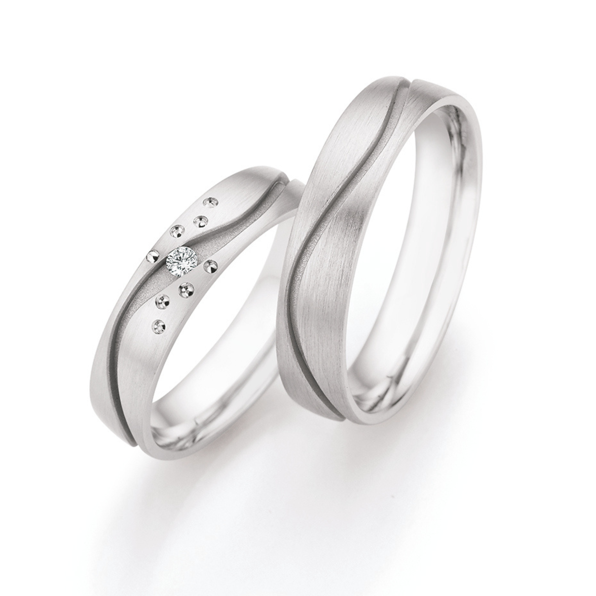 Zwei silberne Eheringe, einer mit Diamant, nebeneinander auf weißem Hintergrund.