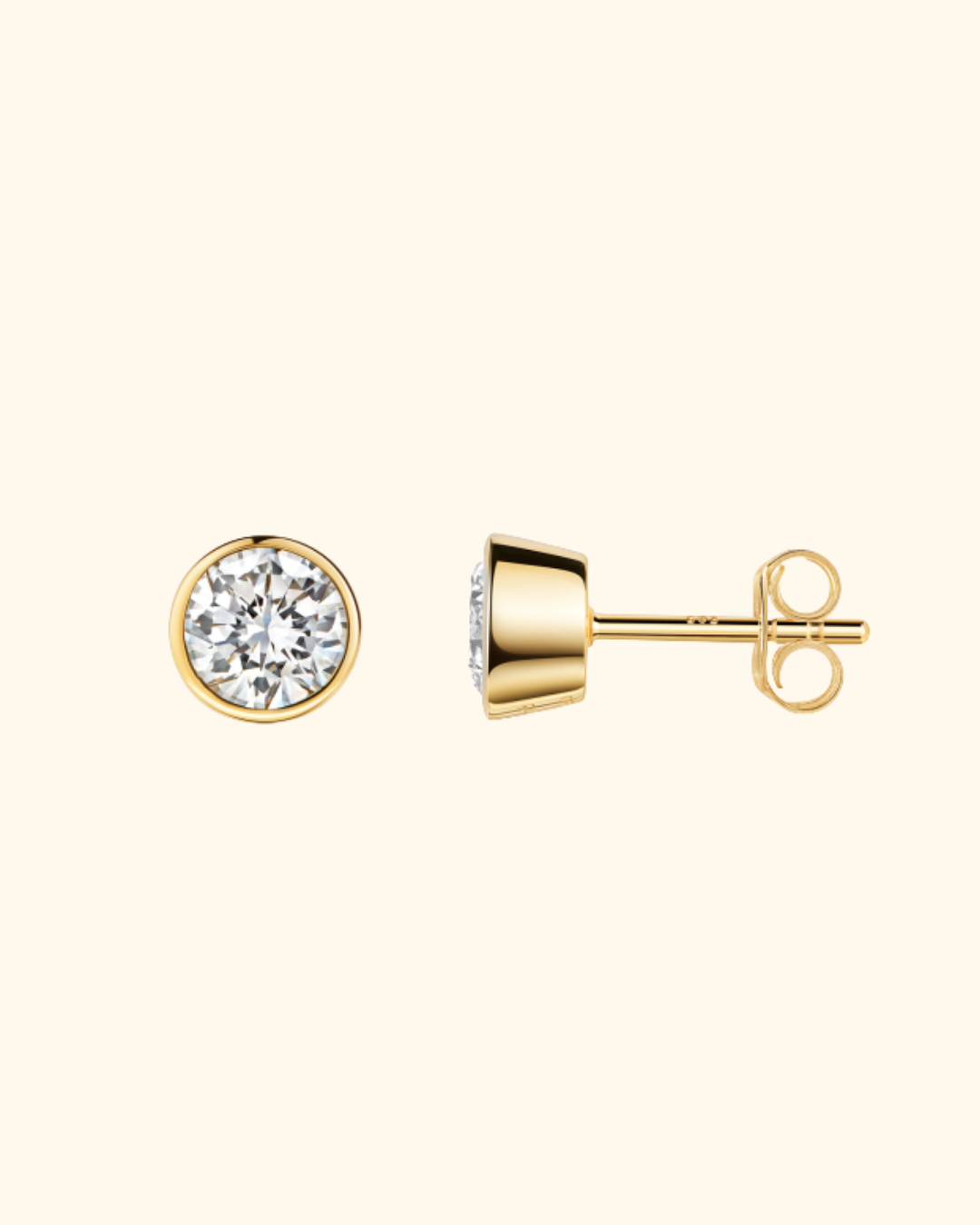 Goldene Ohrstecker mit großen, runden, facettierten Diamanten auf cremefarbenem Hintergrund.
