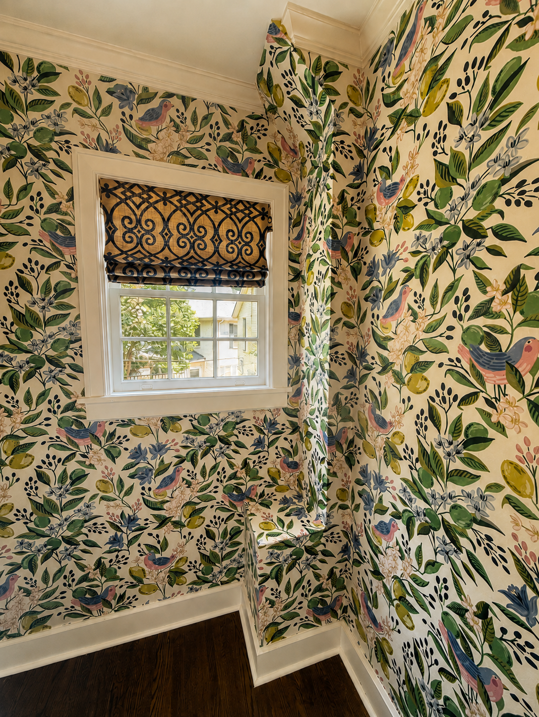 Botanical bird and floral wallpaper professionally installed around a stairway window.