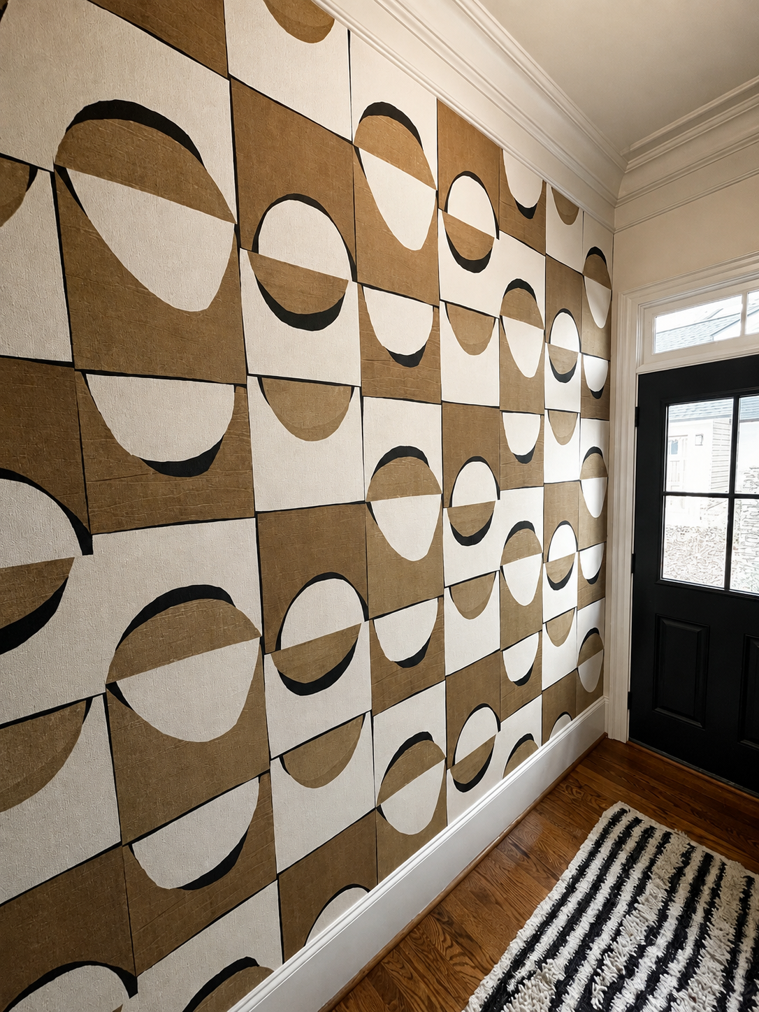 Geometric wallpaper installation in a residential entryway with black, beige, and white pattern.