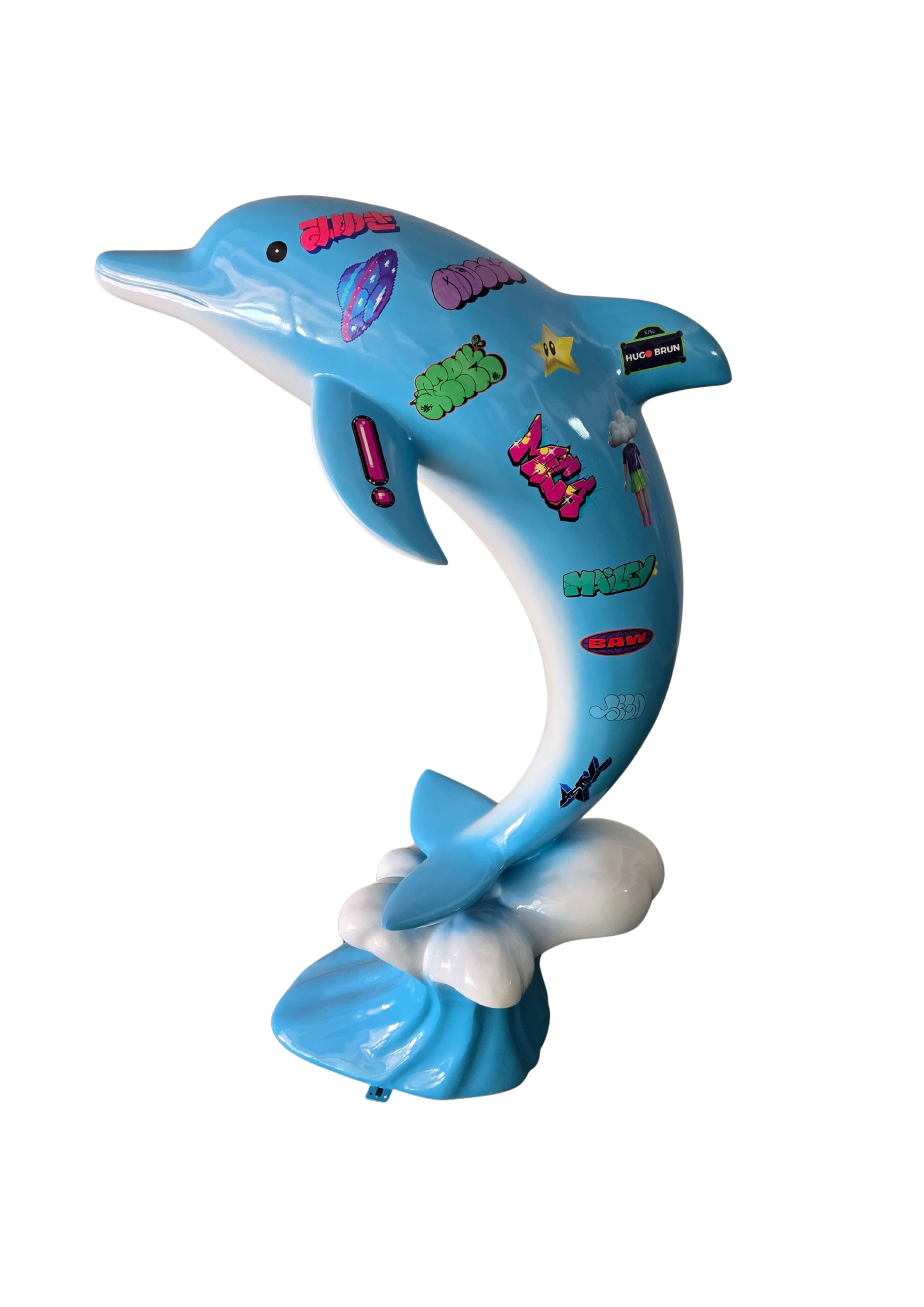 A decorative dolphin sculpture painted light blue with colorful stickers and graphic designs, standing on a cloud-shaped base, against a black background.