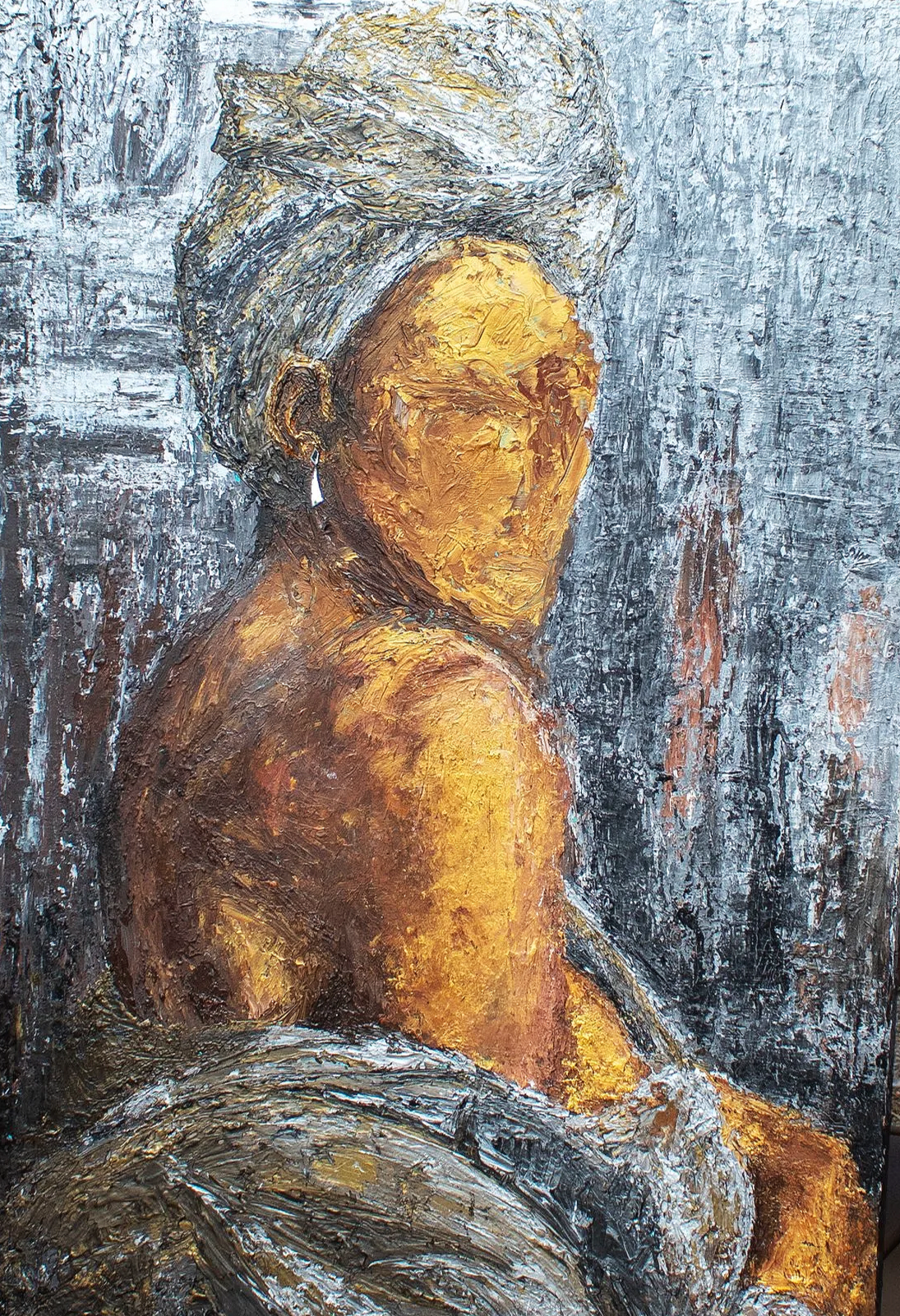 An oil painting of an elderly woman with a textured grey headwrap, wearing a earring, and sitting with her back and shoulder visible, in front of a dark textured background.