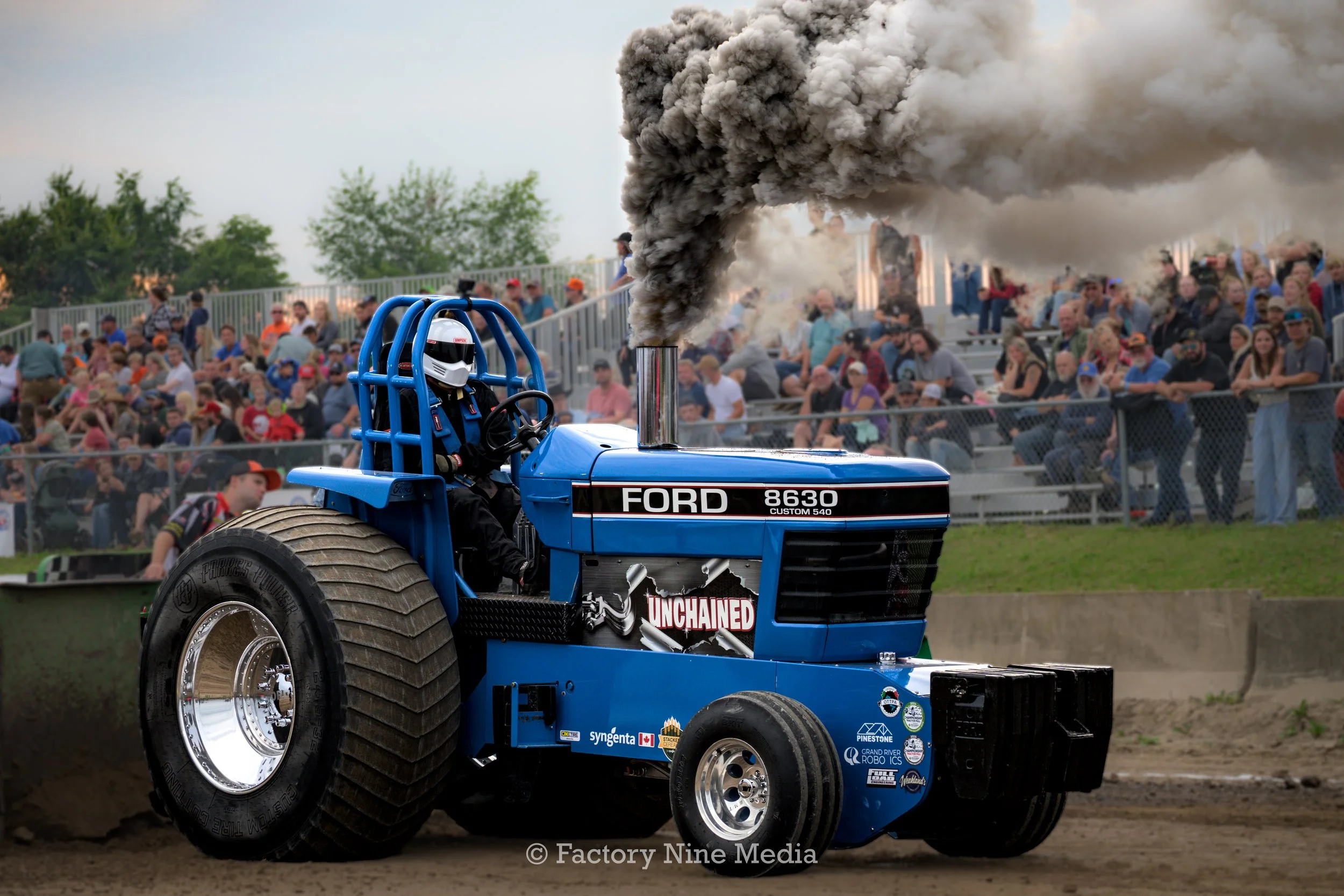 Tractor pull in Barrie, Ontario fall fair. ford tractor shameless with some black diesel smoke in front of a huge crowd. location Essa, Agriplex fairgrounds.