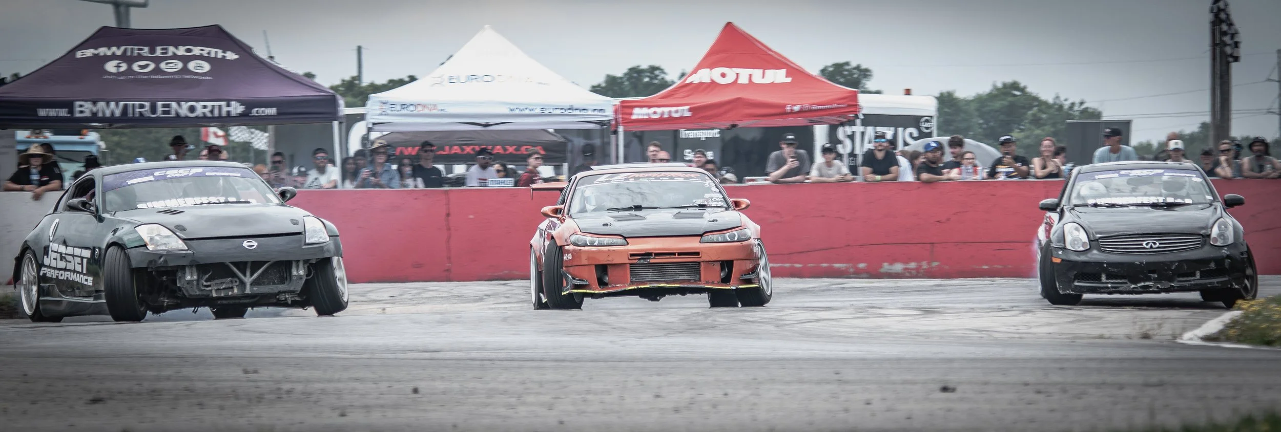 Drift warz at Cayuga race track in Ontario. Three cars drifting around the turn competing for the title of drift king.