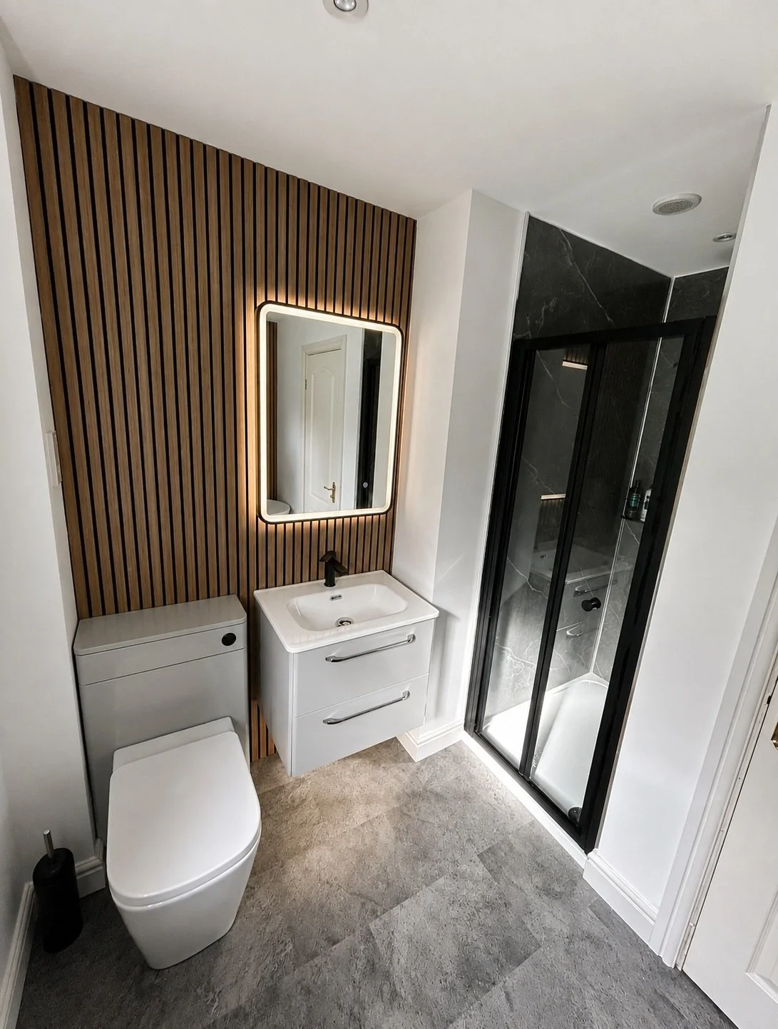modern bathroom with warm wood slat detailing and contemporary grey marble finishes