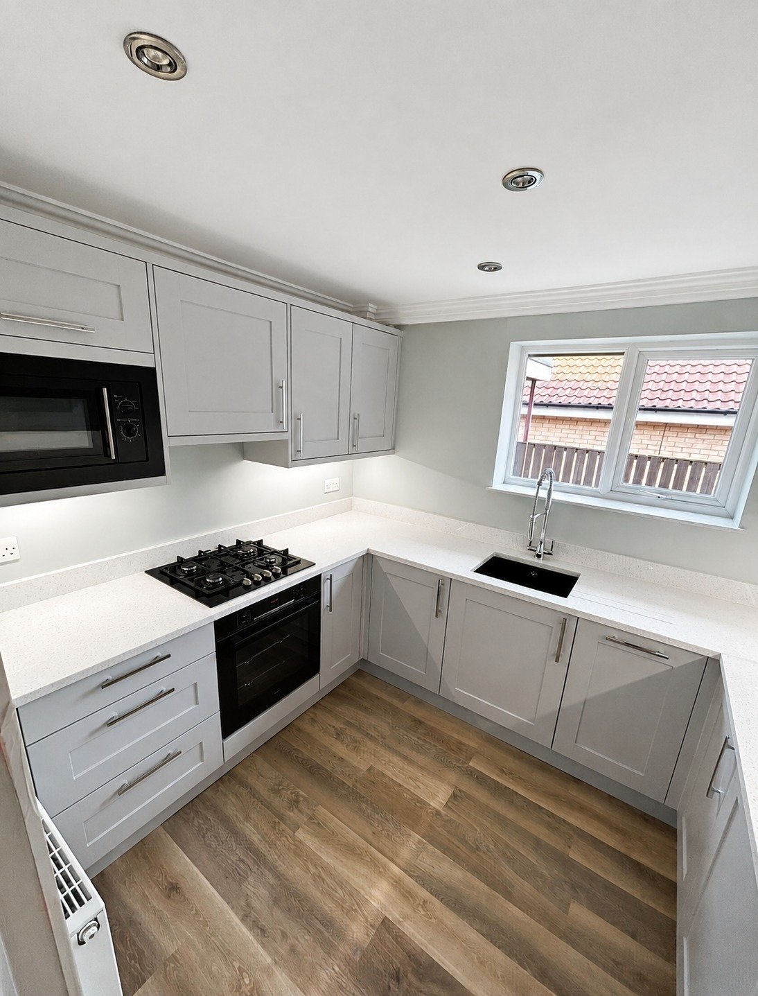 Bright grey Shaker kitchen with warm wood flooring