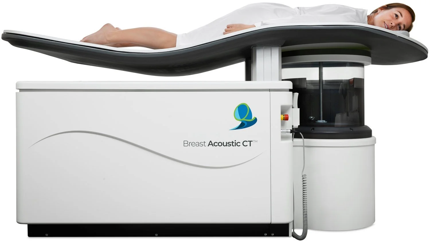Woman lying on a breast MRI machine labeled 'Breast Acoustic CT'