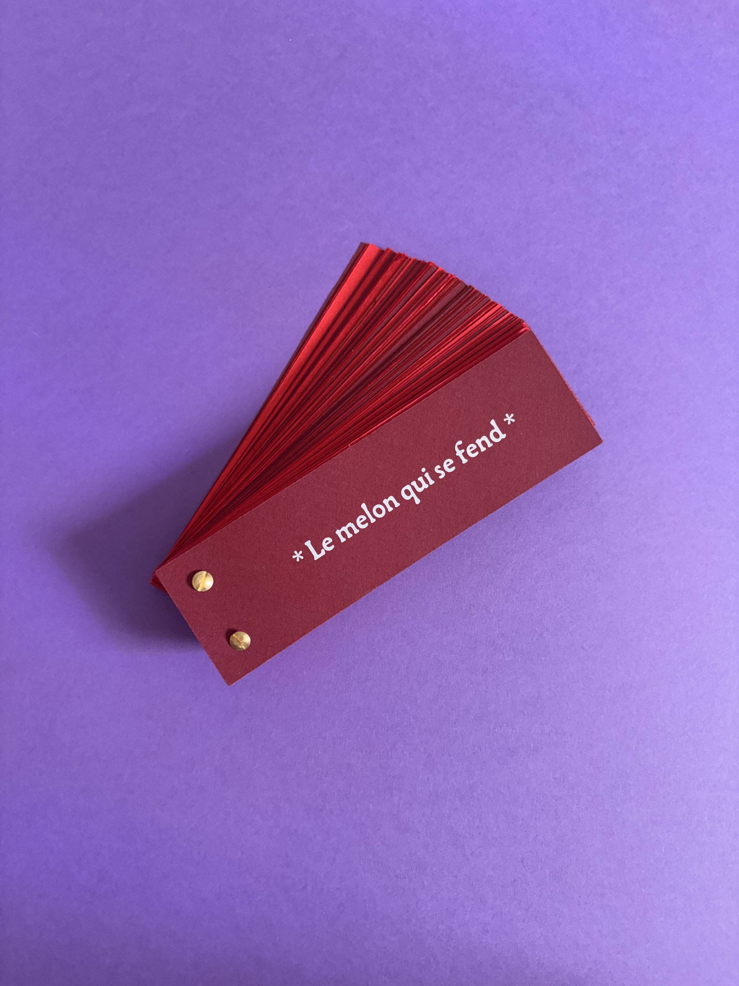 Cartes rouges empilées avec une bande blanche portant un texte en français, posé sur un fond violet.
