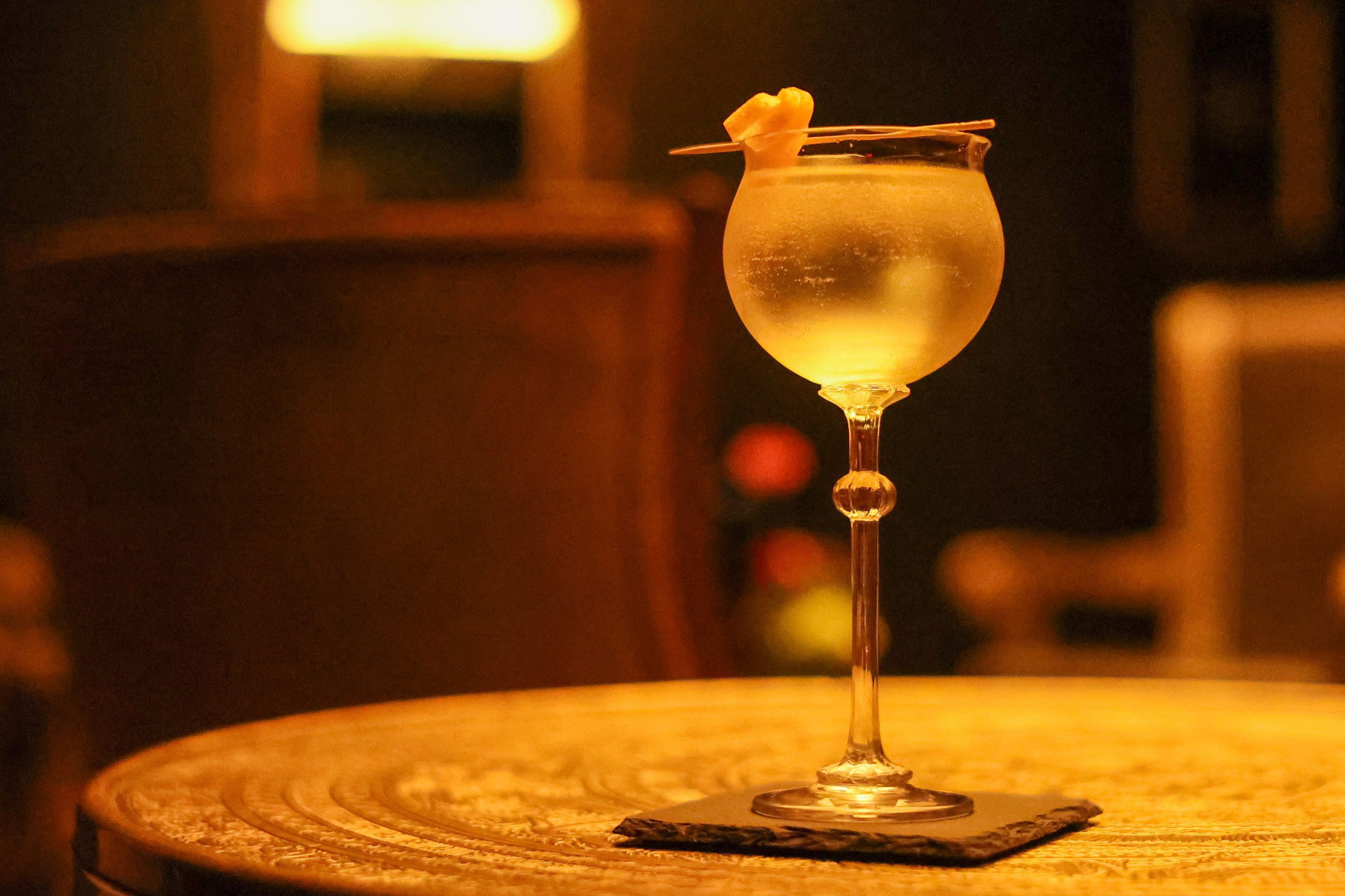 Cocktail photographed in a dimly lit restaurant setting.