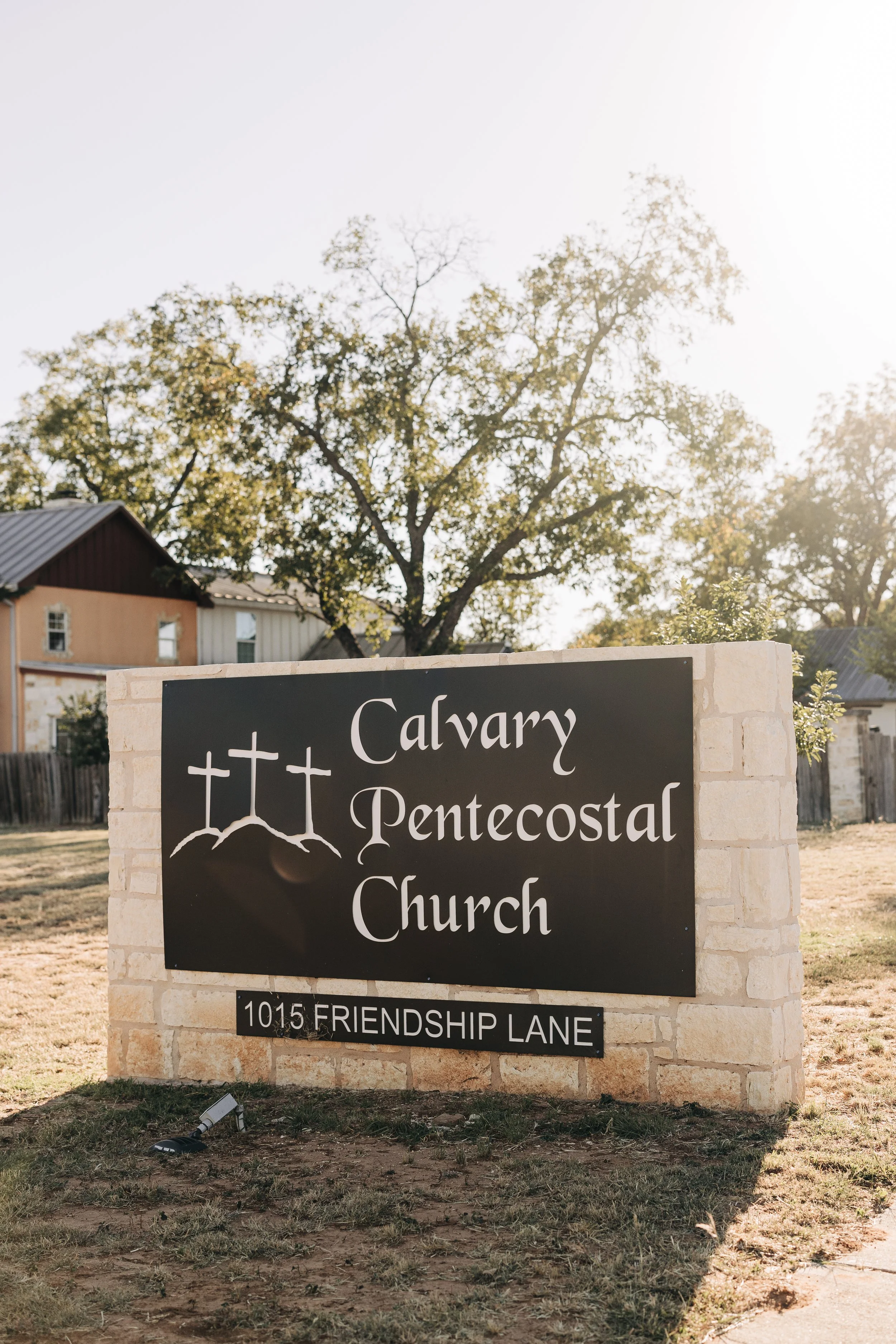Calvary Pentecostal Church sign at 1015 Friendship Lane, surrounded by trees and church buildings.