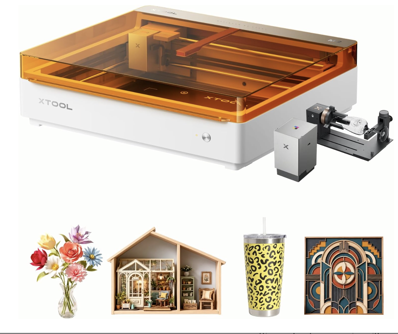 A digital cutting machine with a transparent orange lid, a small control box, and a rotary attachment for engraving glass. Below the machine are a flower bouquet, a miniature dollhouse, a leopard print tumbler with a straw, and an abstract geometric wall art piece.