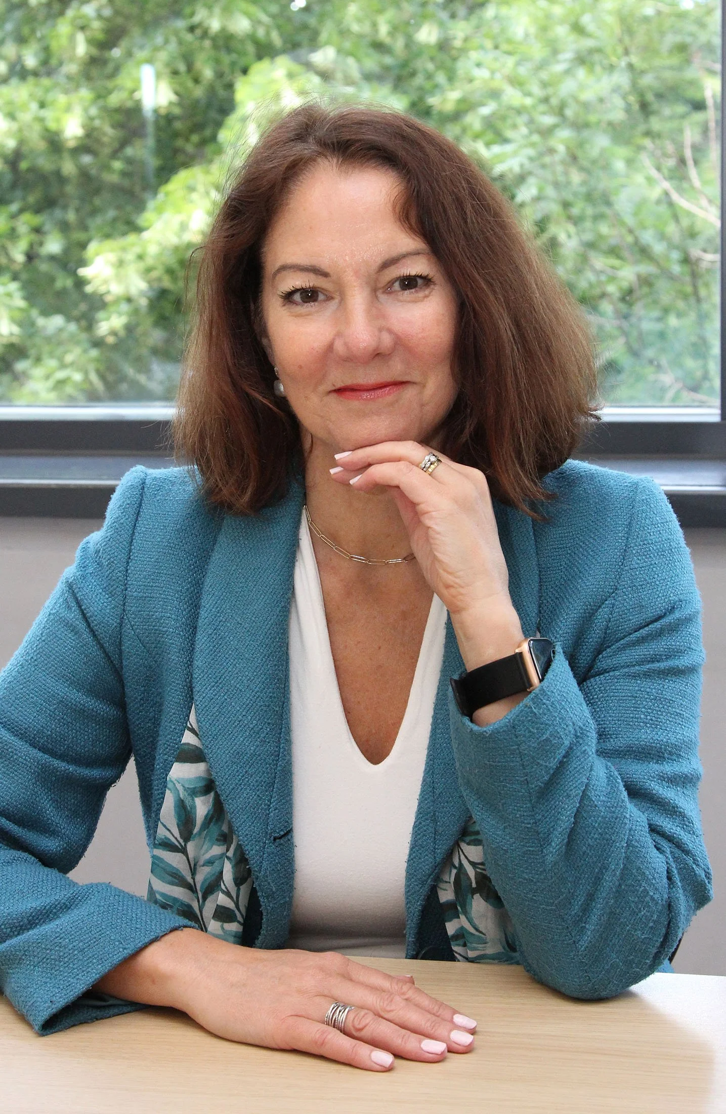 Fiona Allen-Pusey wears a blue blazer and a scarf with a leaf motif