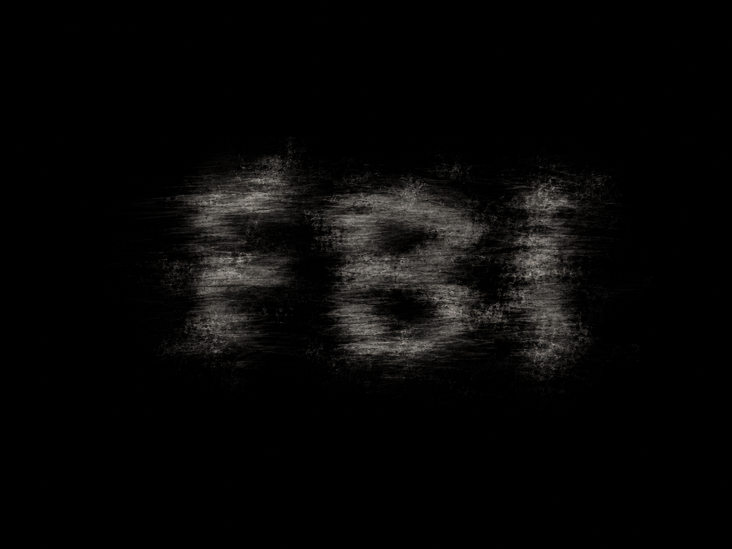 Distressed and blurred three-letter graphic on a black background.
